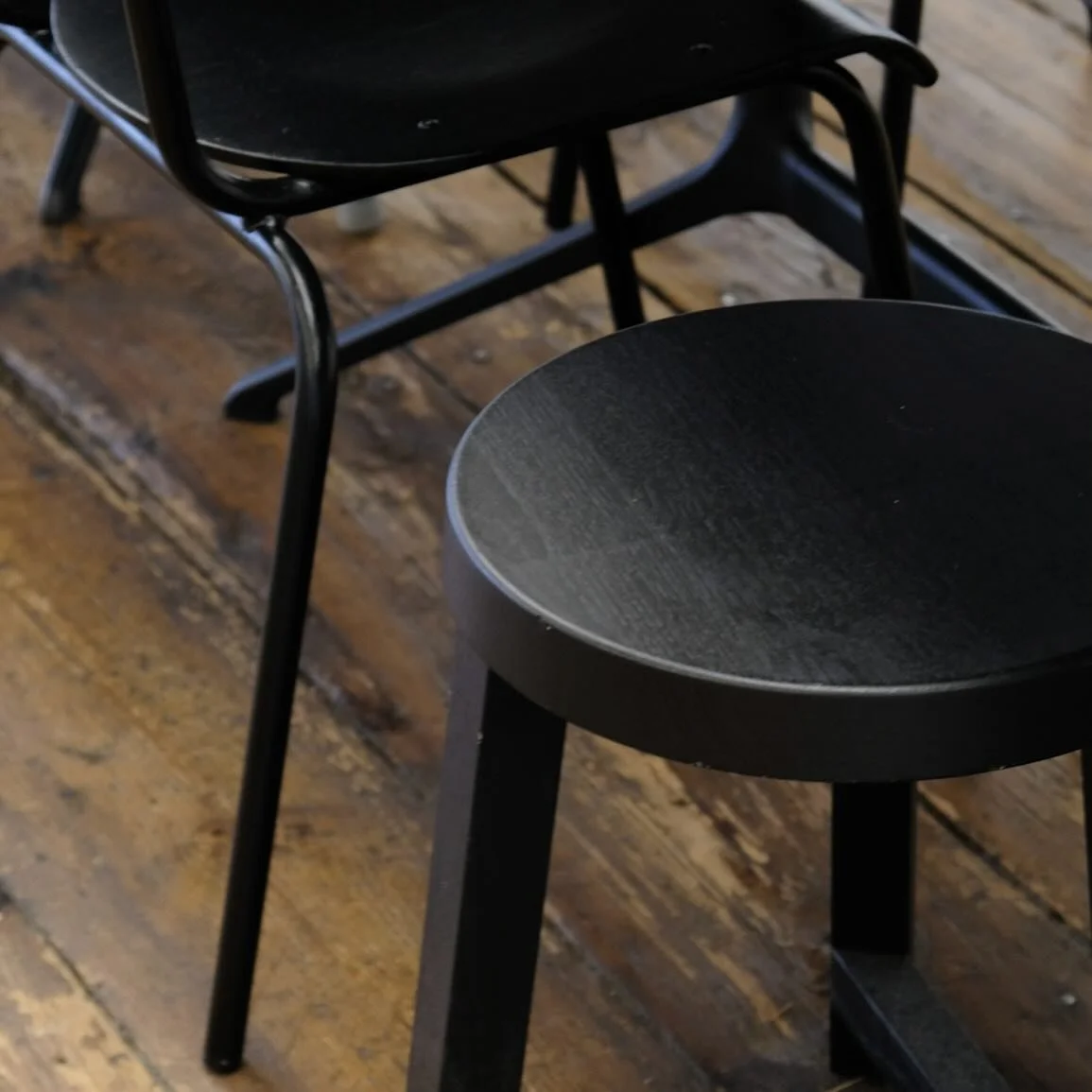 contrast is in the details — modern black furniture compared with a timeless hardwood floor. the perfect balance of warmth and minimalism.