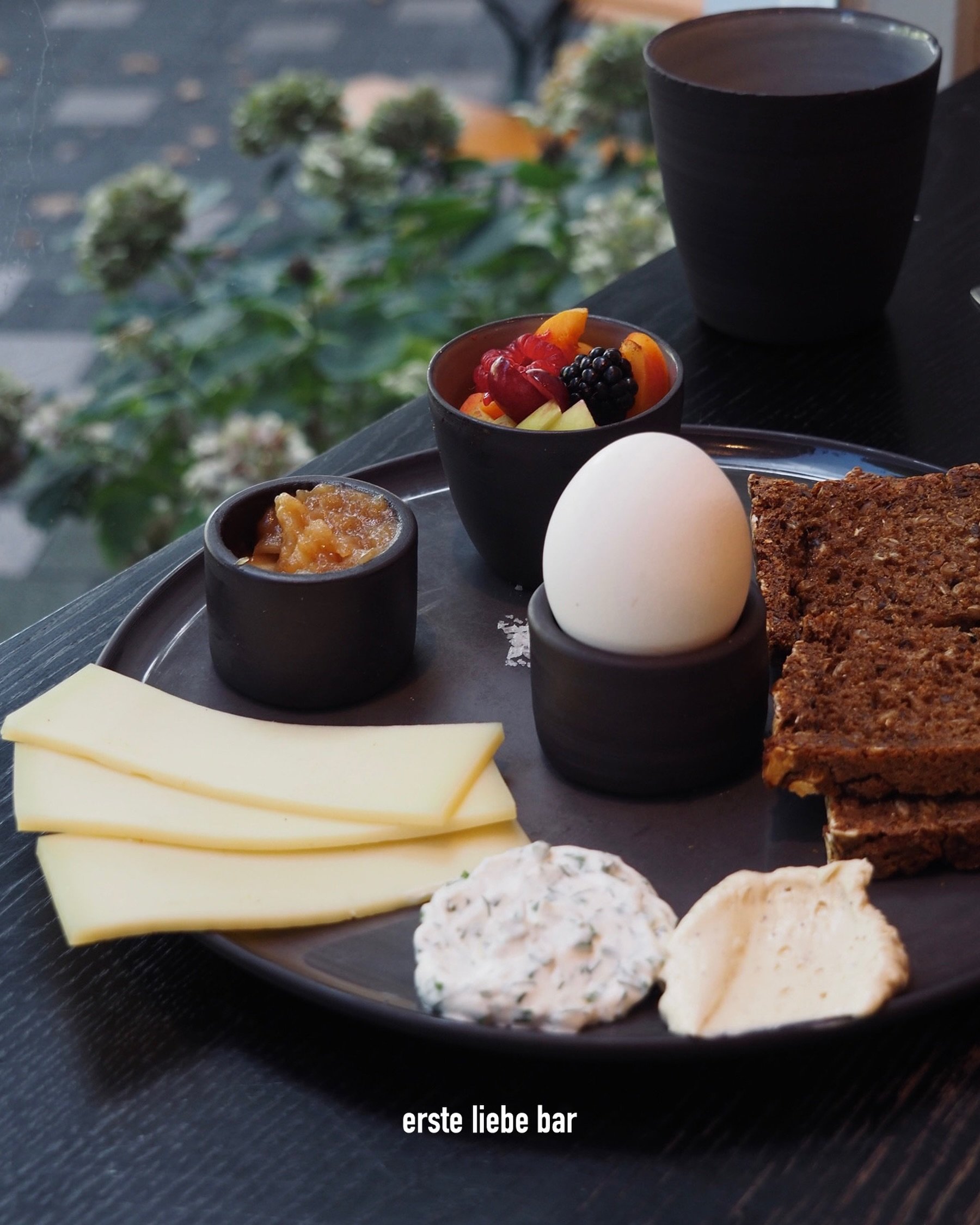 breakfast plate, with our homemade danish rugbr&oslash;d, whipped brown butter, cream cheese with fresh herbs, local cheese, seasonal fruit, a soft boiled organic egg &amp; seasonal compote.