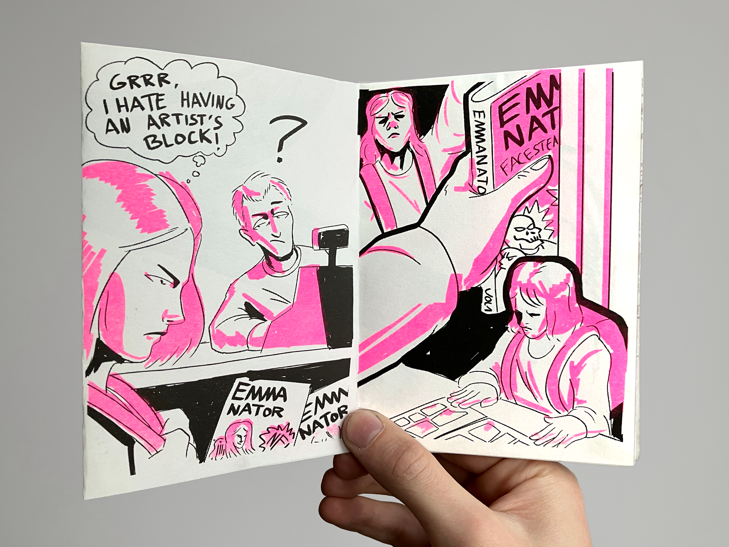 A black and white and pink comic strip featuring a woman frustrated with an artist's block, buying a book titled 'Emma Nator' at a bookstore. She looks at the book with concern while a man appears to be recording her, and another woman is seated, loo
