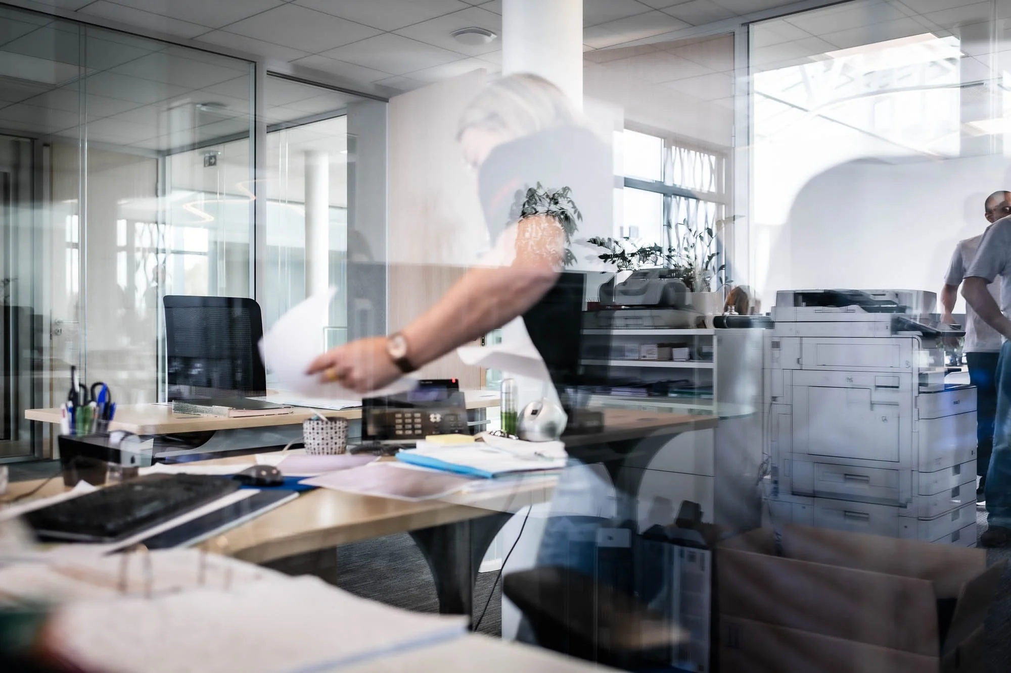 Bureau moderne avec des personnes, des ordinateurs et une imprimante.
