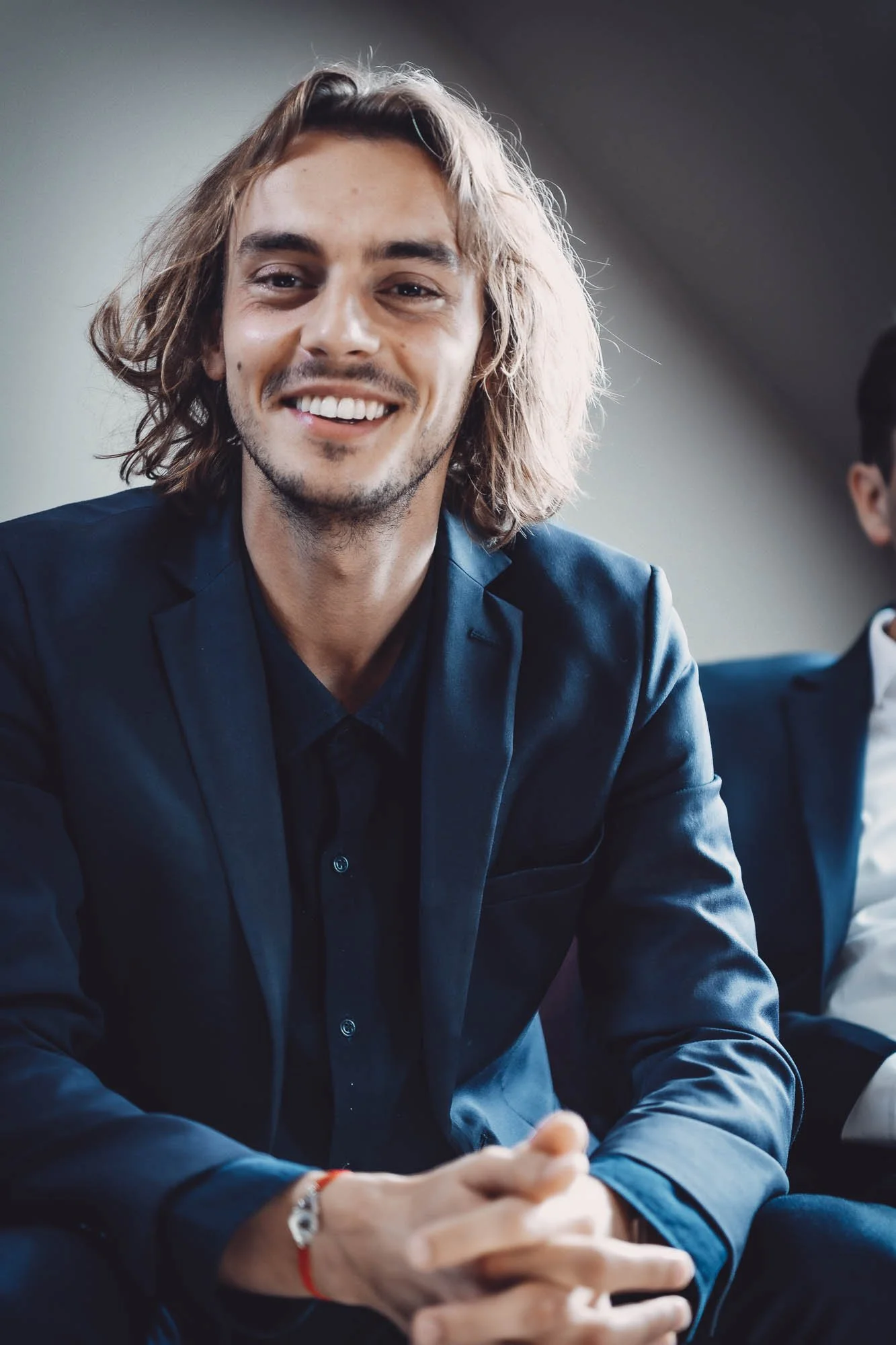 Homme souriant en costume assis