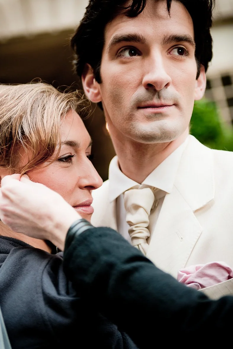 Deux personnes posant, l'homme en costume blanc.