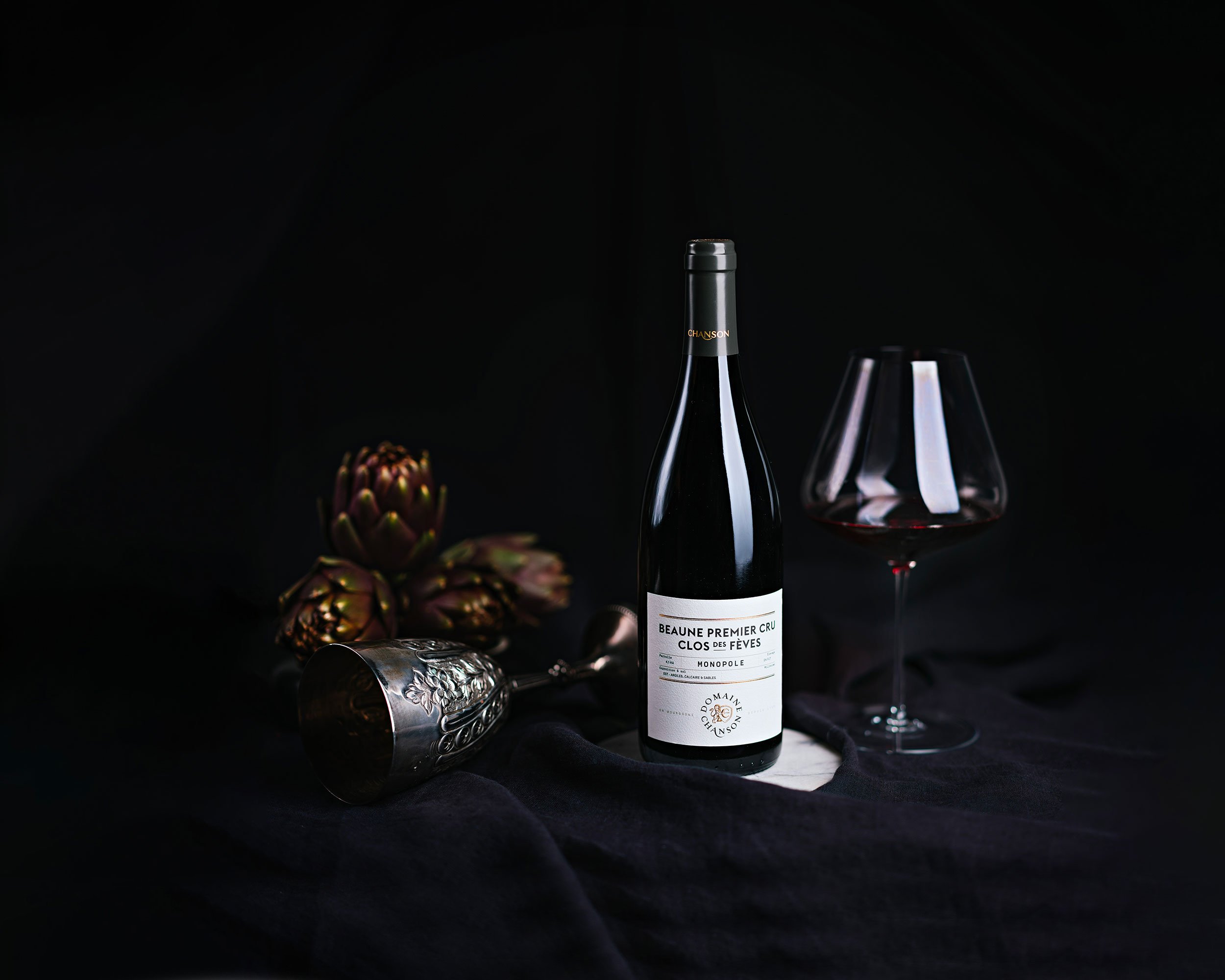 Photographie de nature morte d’une bouteille de vin Beaune Premier Cru Clos des Fèves du Domaine Chanson, direction artistique, stylisme et image de marque par Emma Brante – Le Ciel est Bleu Studio