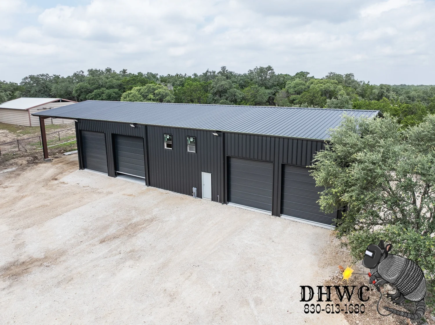 Matte black metal shop with four roll-up doors in Boerne, TX