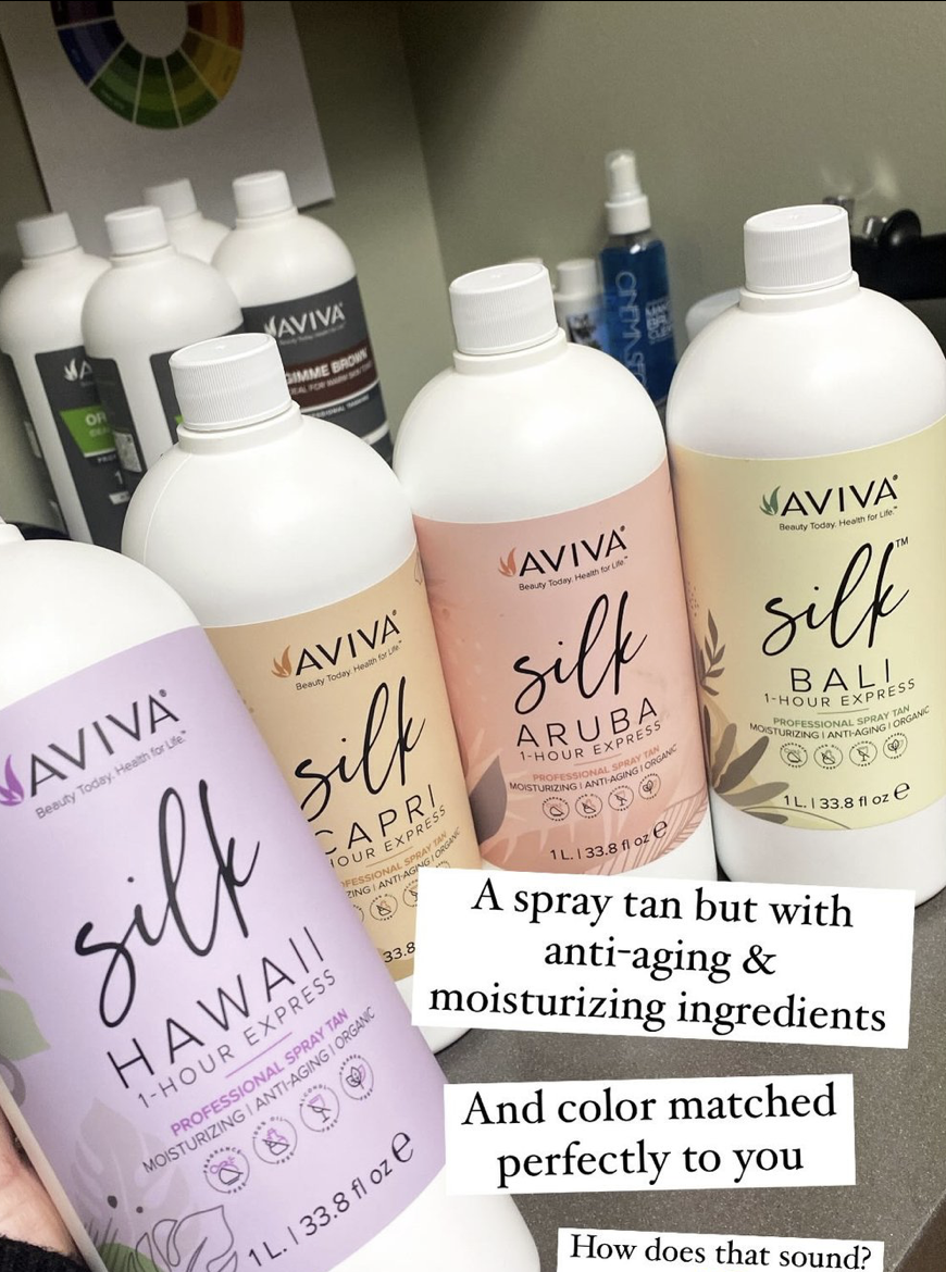 Four bottles of Aviva spray tan labeled Silk Hawaii, Silk Capri, Silk Aruba, and Silk Bali, each with moisturizing, anti-aging, and organic ingredients.