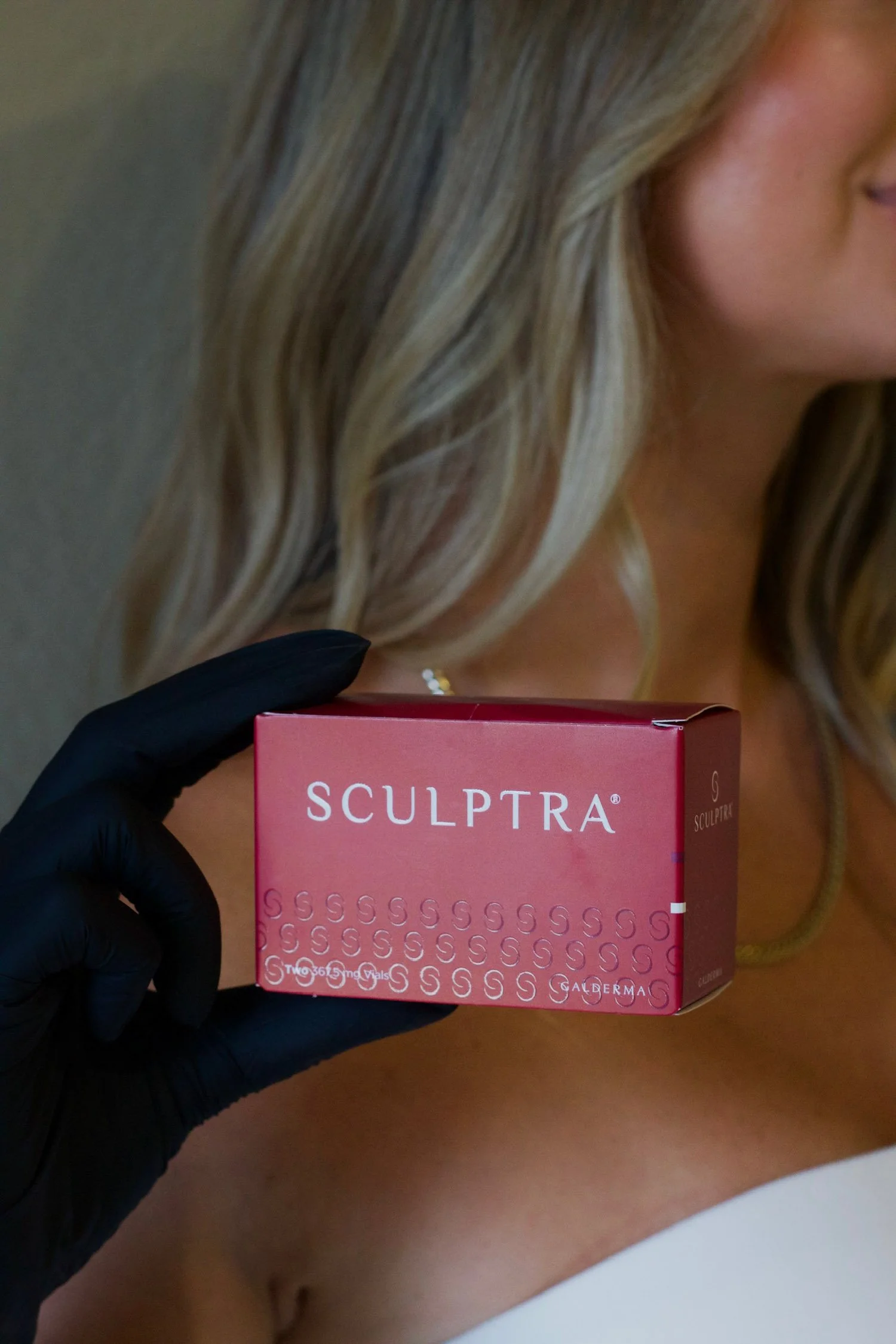 Jennifer Krejcarek holding Sculptra biostimulator for collagen-stimulating injectable treatments at VAIN OBX