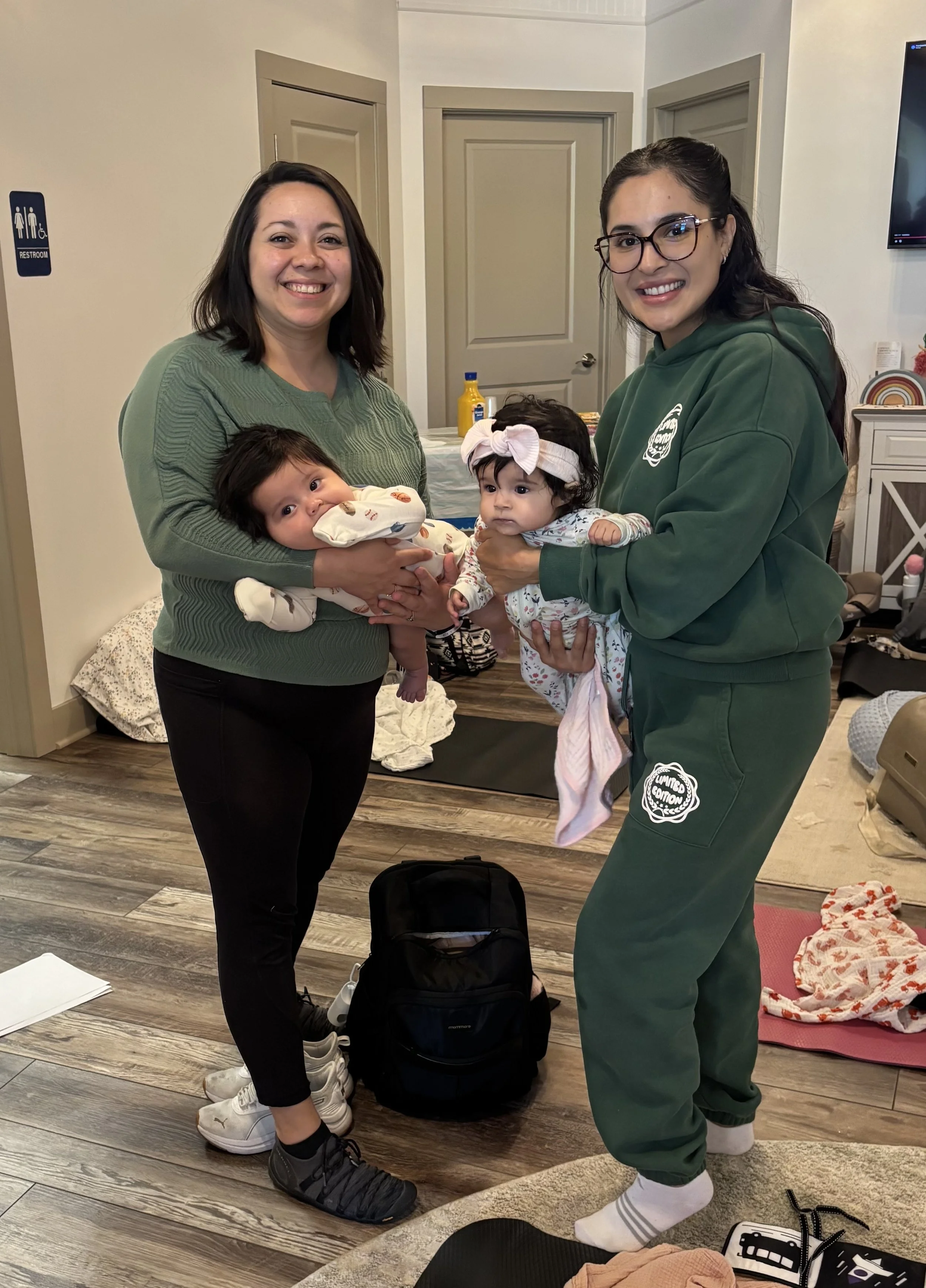 Women with dark hair holding thier newborn babies, waiting to have a pediatric adjustment for her baby by a local Cary, IL family chiropractor.