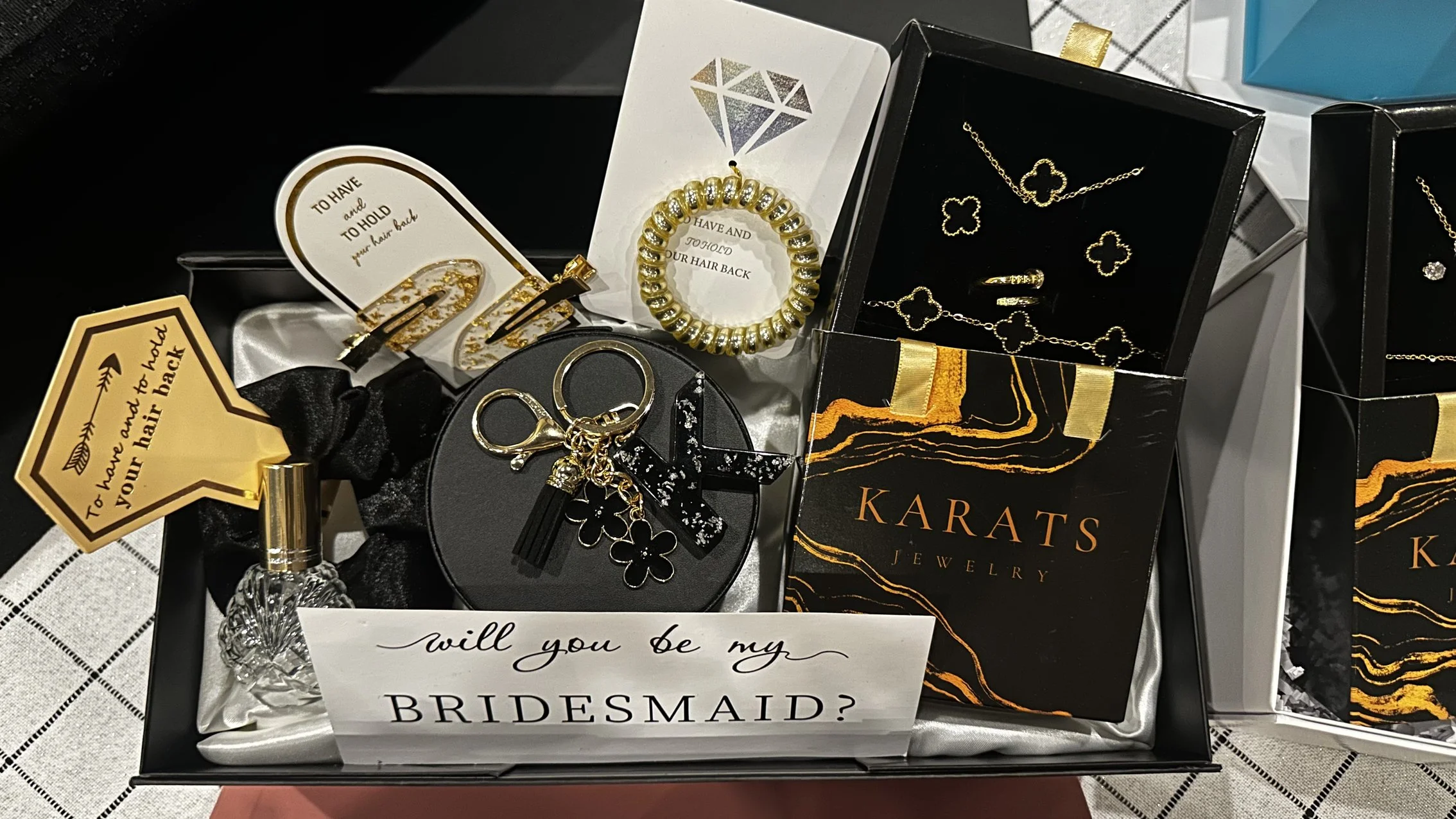 Gift box containing jewelry items, hair accessories, and a note asking "Will you be my bridesmaid?"