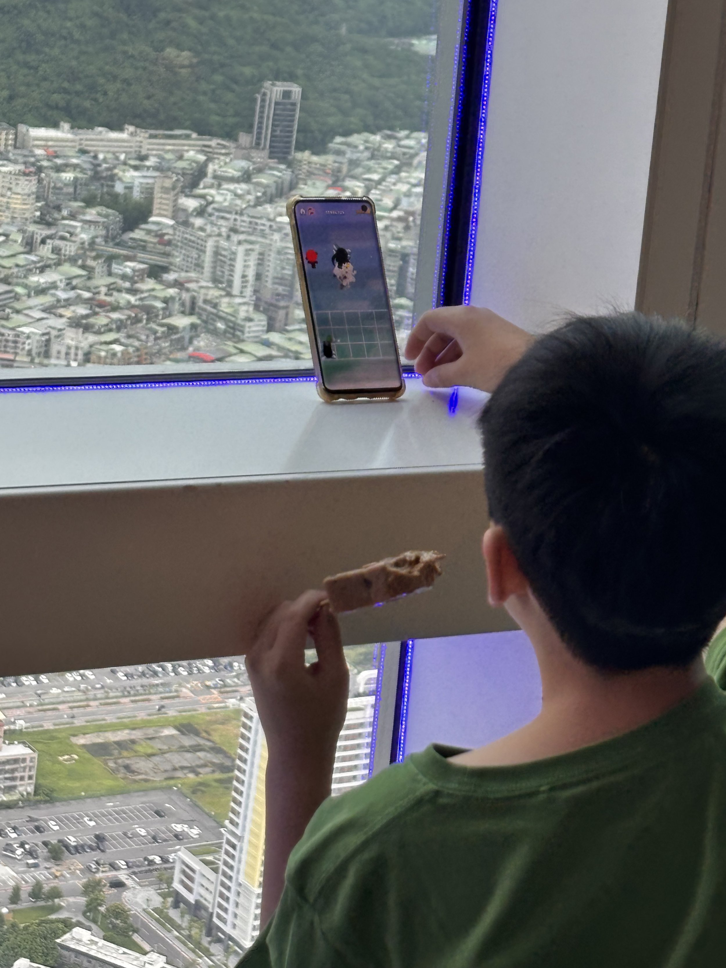 random chinese boy ignoring the view and playing a game instead