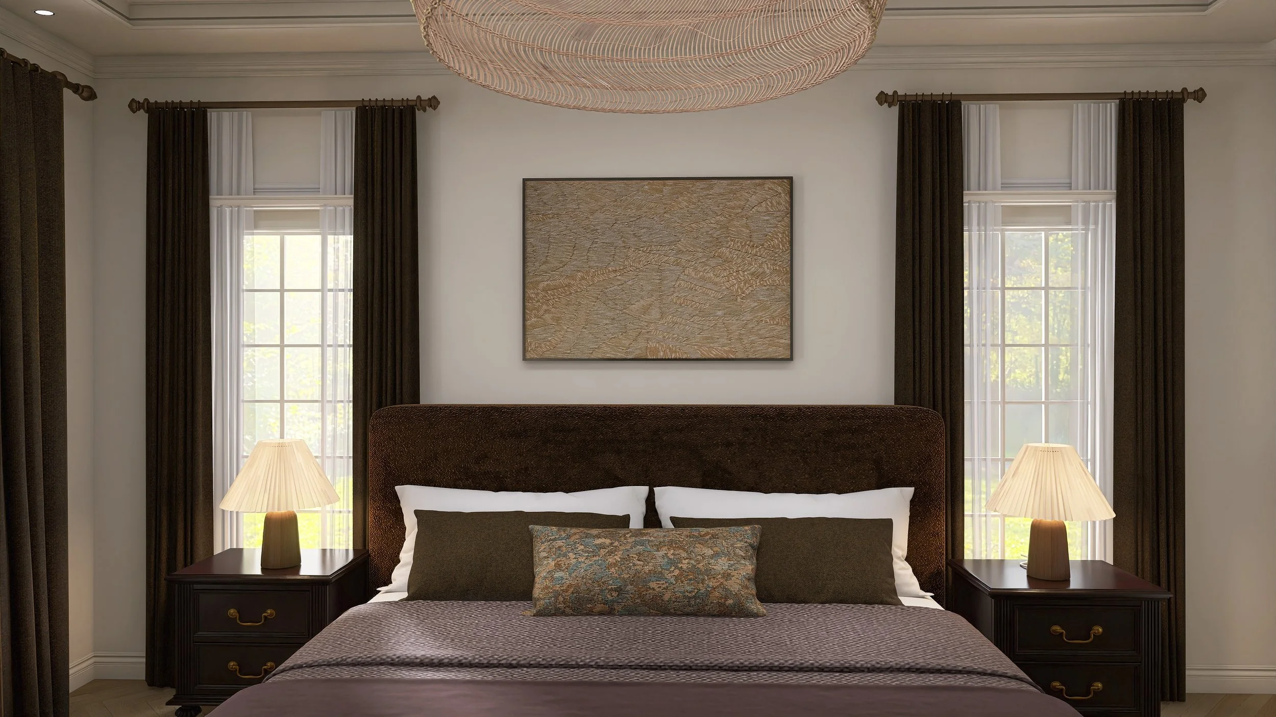 A bedroom with a large headboard, two bedside tables with lamps, and three pillows on the bed. There are two windows with curtains on either side of a framed artwork on the wall.