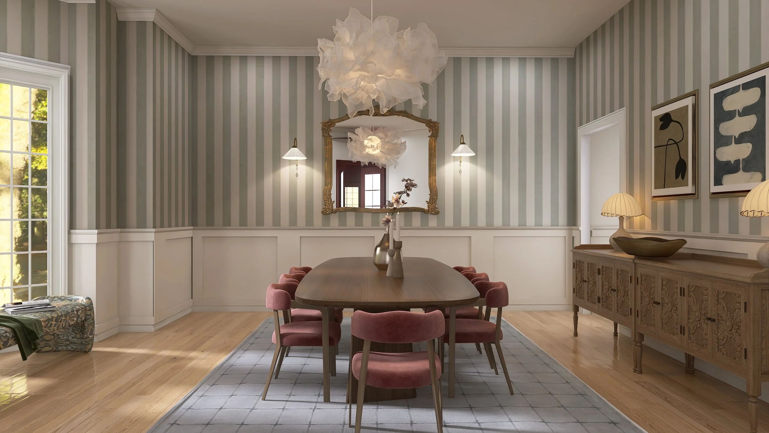 A dining room with a wooden table surrounded by pink chairs, a large mirror with a gold frame, a sideboard with a lamp, decorative vases, and artwork on the walls. There is a window with sunlight and a patterned ottoman visible on the left.