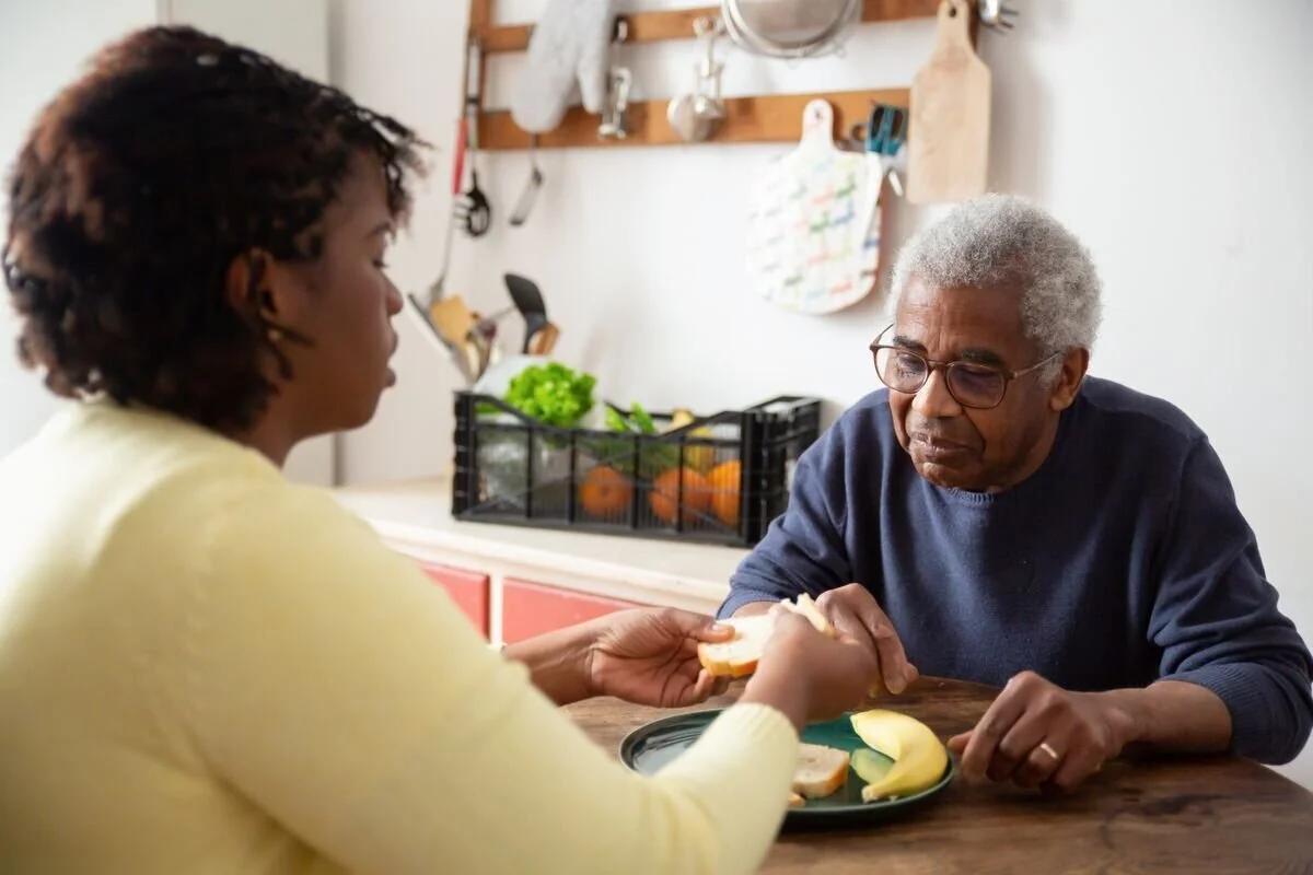 A caregiver sharing a meal with a client at home