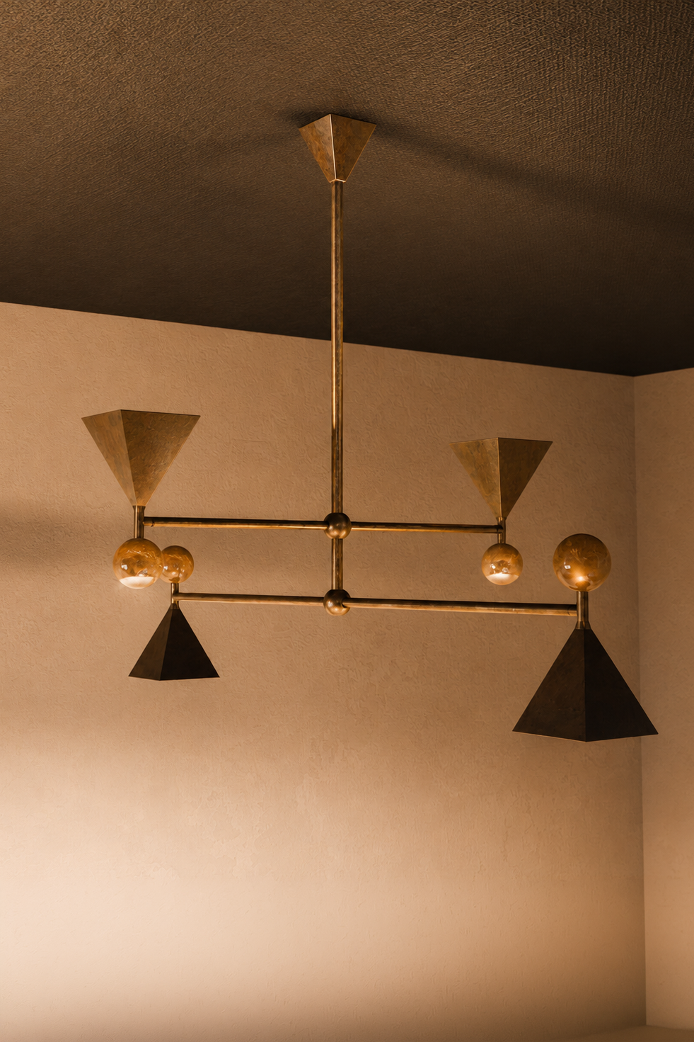 A modern chandelier with geometric black and gold cone-shaped shades and clear glass globes hanging from a metallic structure, mounted on a textured ceiling.