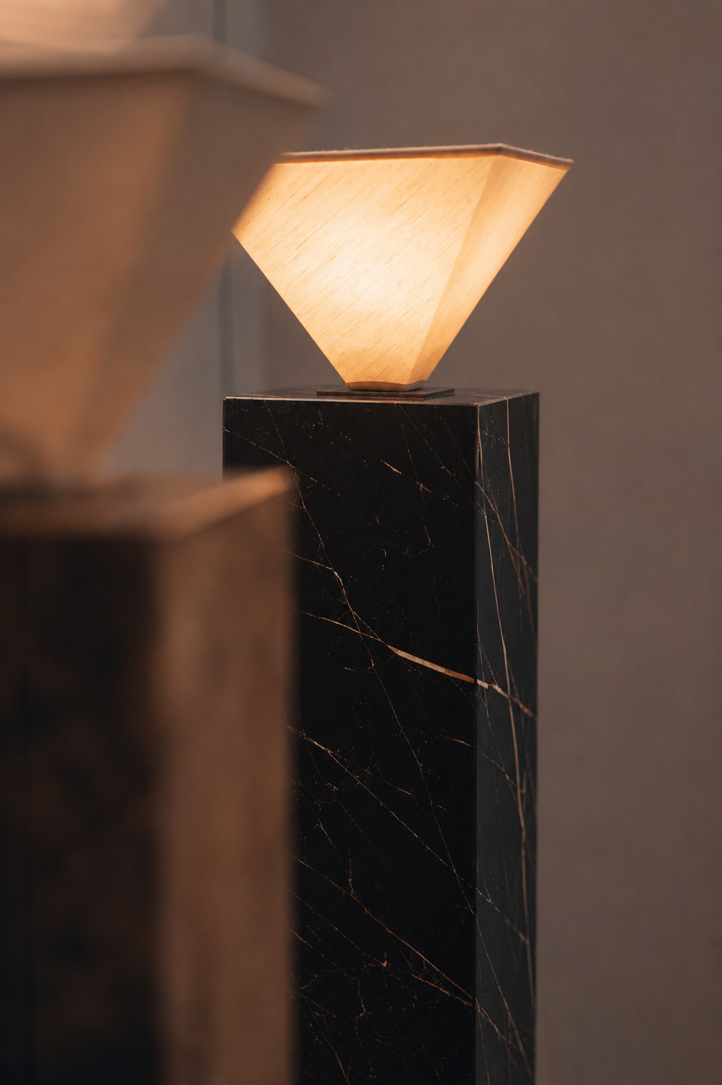 Close-up of a modern table lamp with a wooden shade and a black marble base.