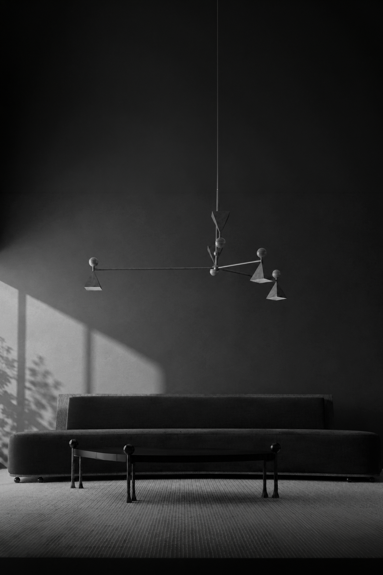 A modern, geometric chandelier hanging from a dark ceiling in a minimally decorated room. A couch and a table are partially visible in the foreground.