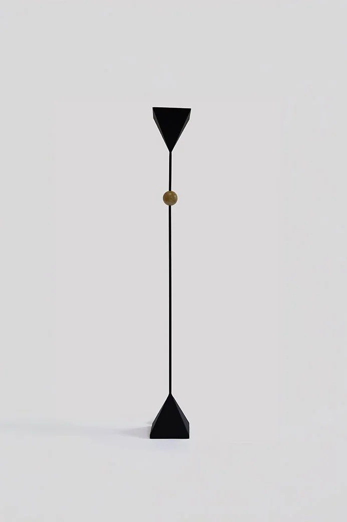 A minimalist black arrow with a wooden ball in the middle, standing vertically on a plain white background.