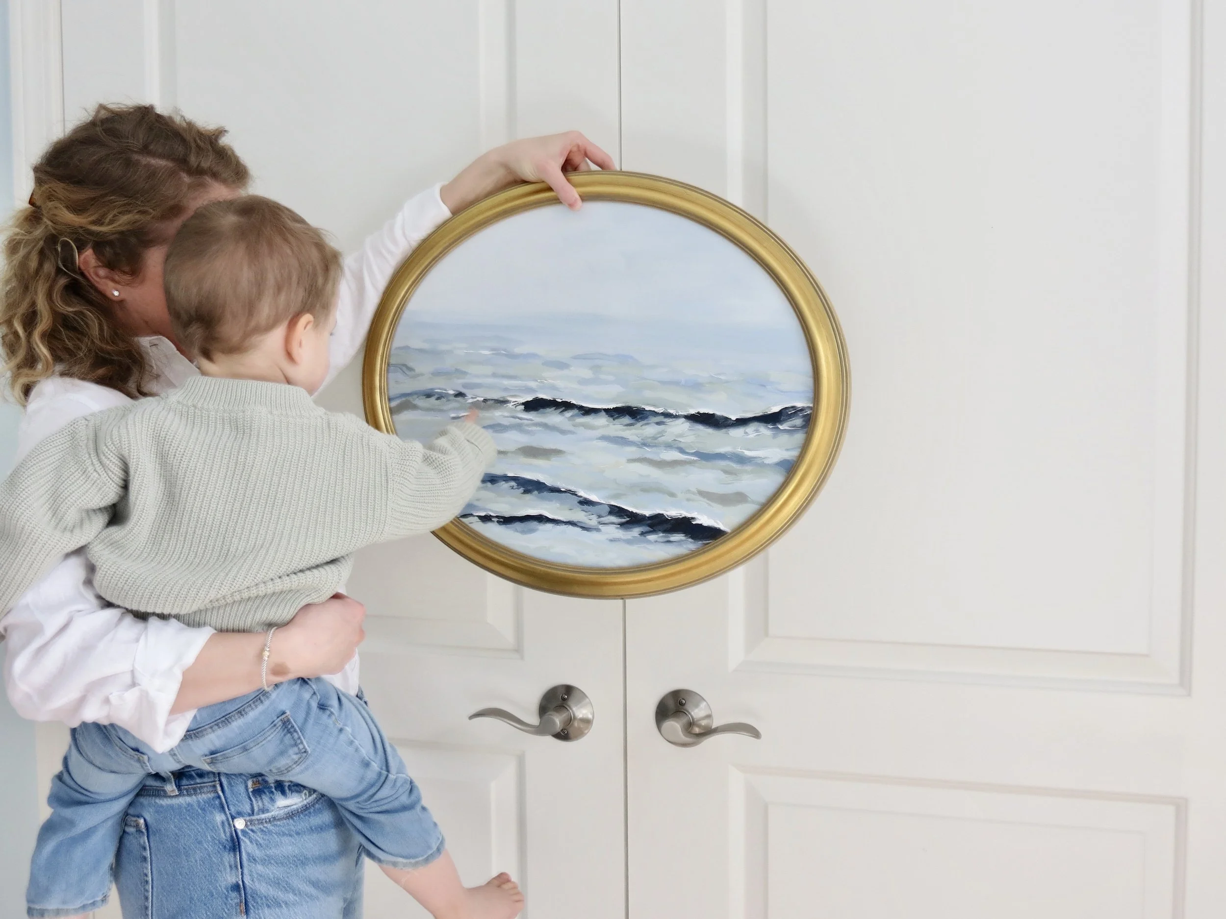 Mother and child with seascape gold framed painting