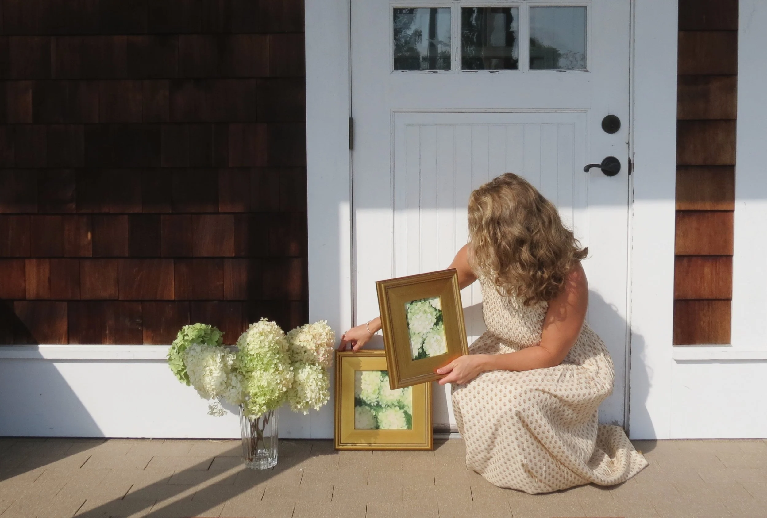New England Artist Rachel Champa - end of summer limelight hydrangea paintings set in front of weathered cedar shakes and crisp white trim, glass vase, hydrangea bloom bouquet, Marea brand dress