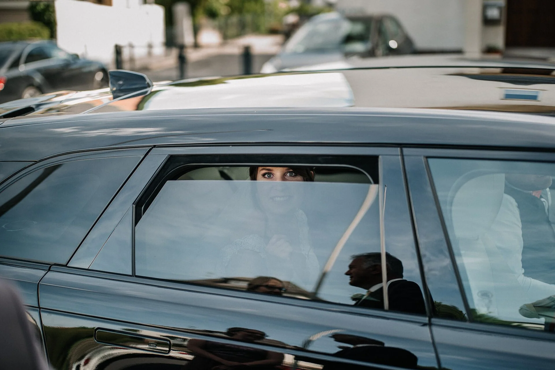 Eine Frau sieht durch die Autofenster in einen schwarzen Wagen, während sie draußen ist.