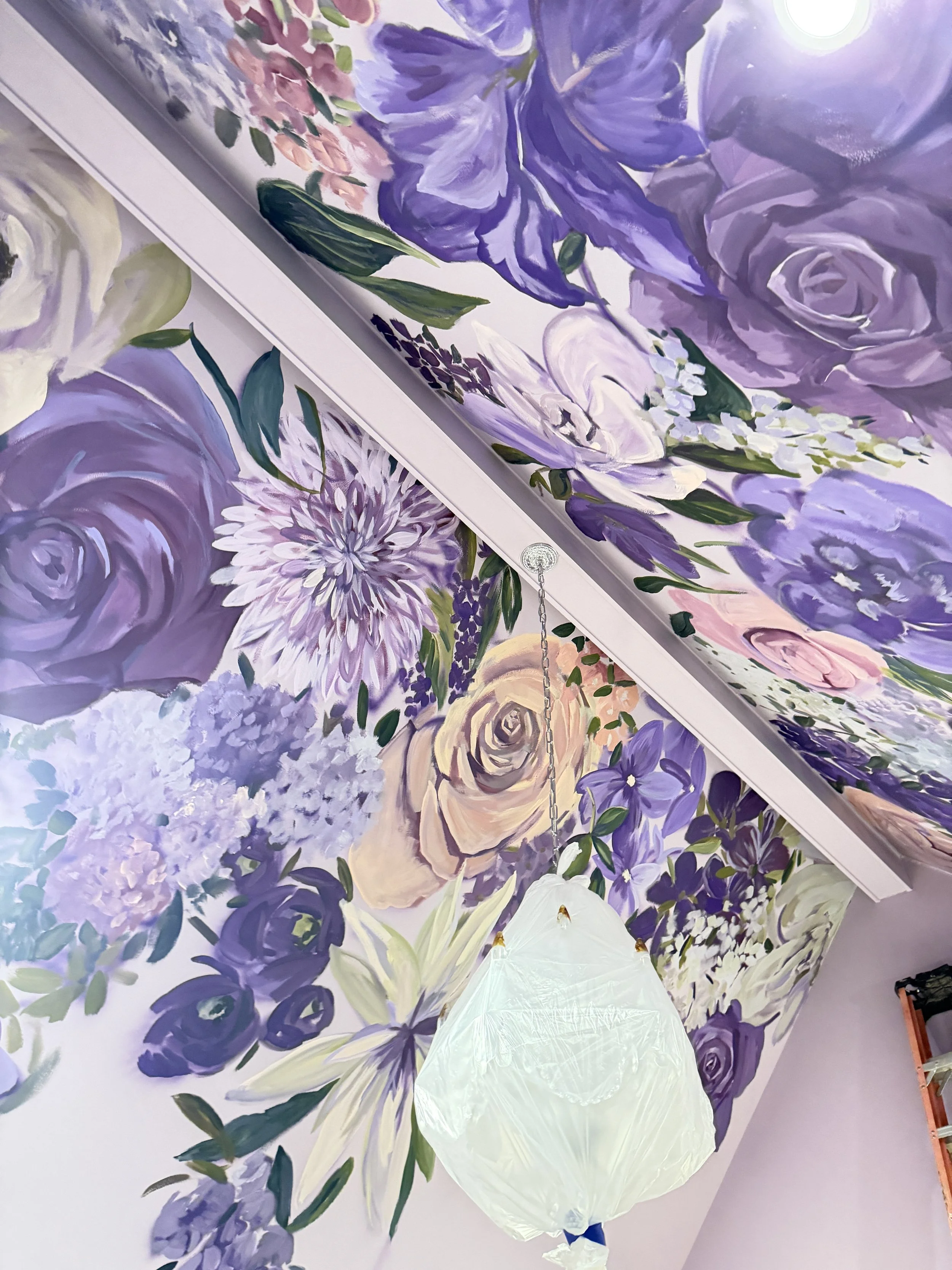 Mural on wall and ceiling of dozens of purple flowers