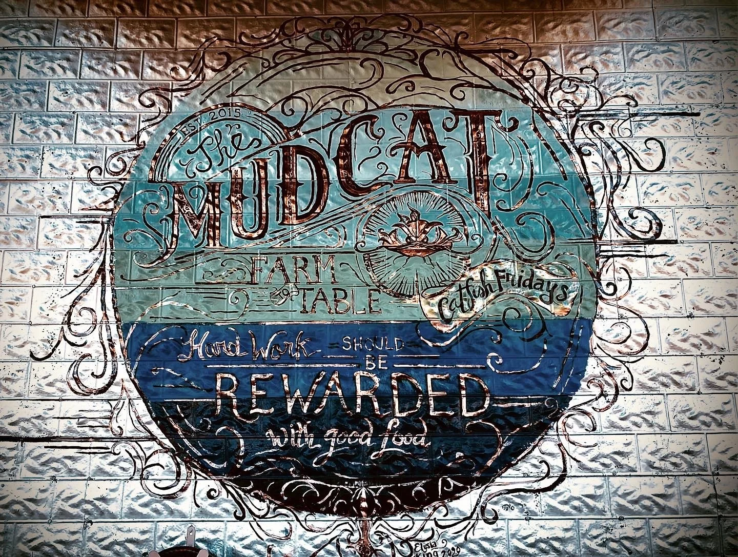 Outdoor mural at the Mudcat Cafe featuring the text
