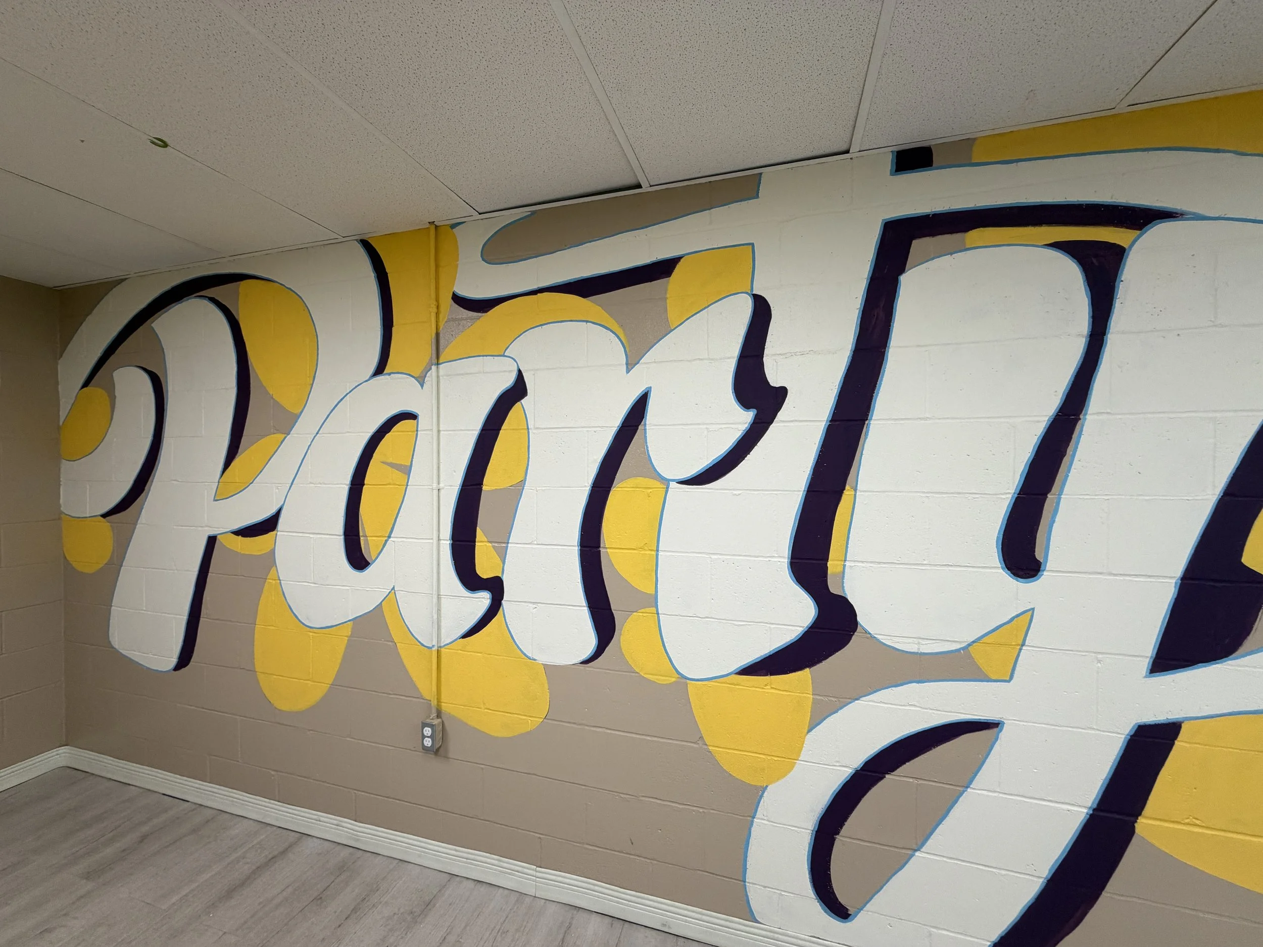 Mural of hand lettered words saying "Party" with yellow organic shapes behind it