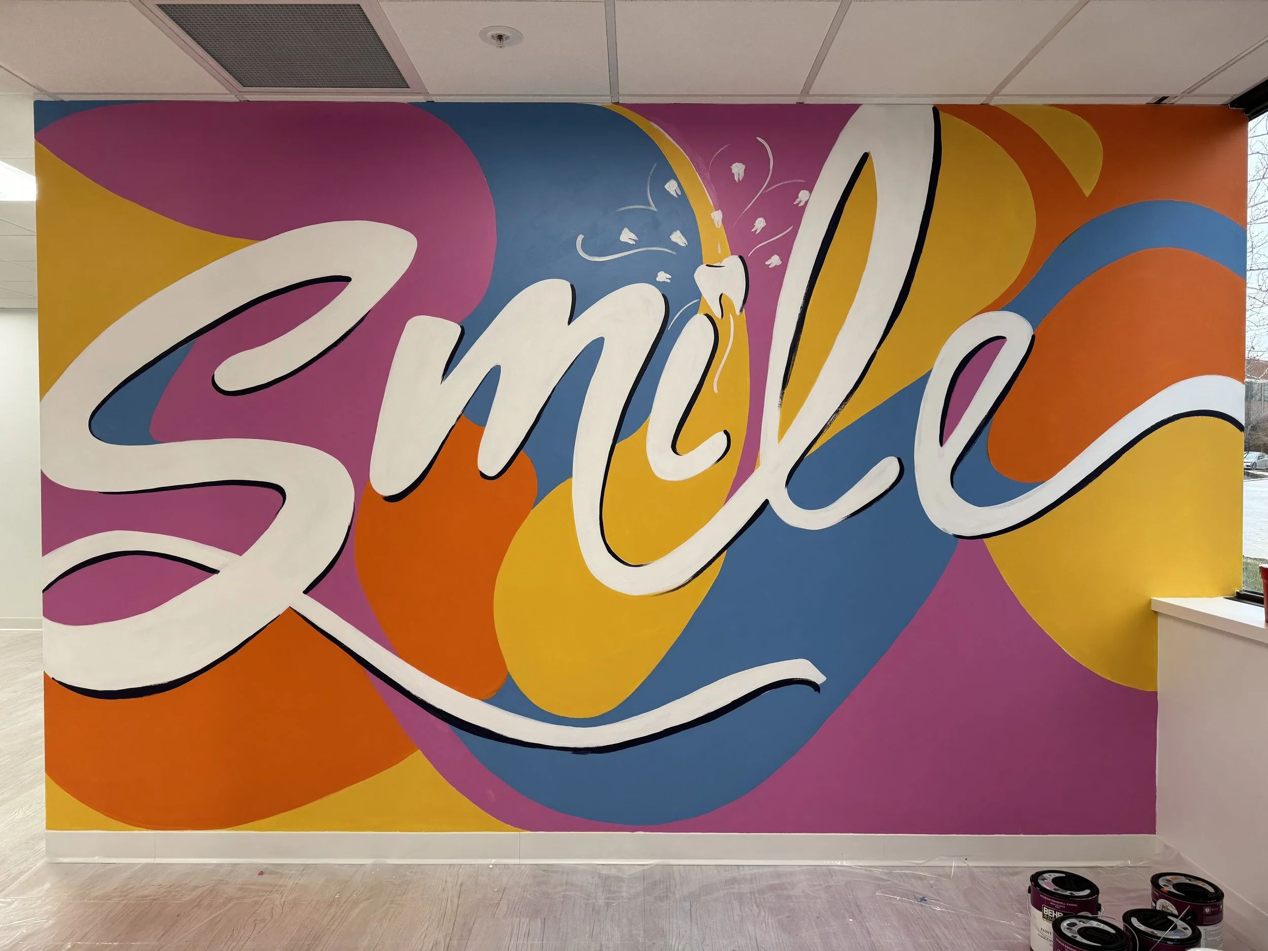 Mural of the word "Smile" with a tooth dotting the "I" against blobs of color in purple, orange, yellow, and blue at Kid's Smiles Pediatric Dentist