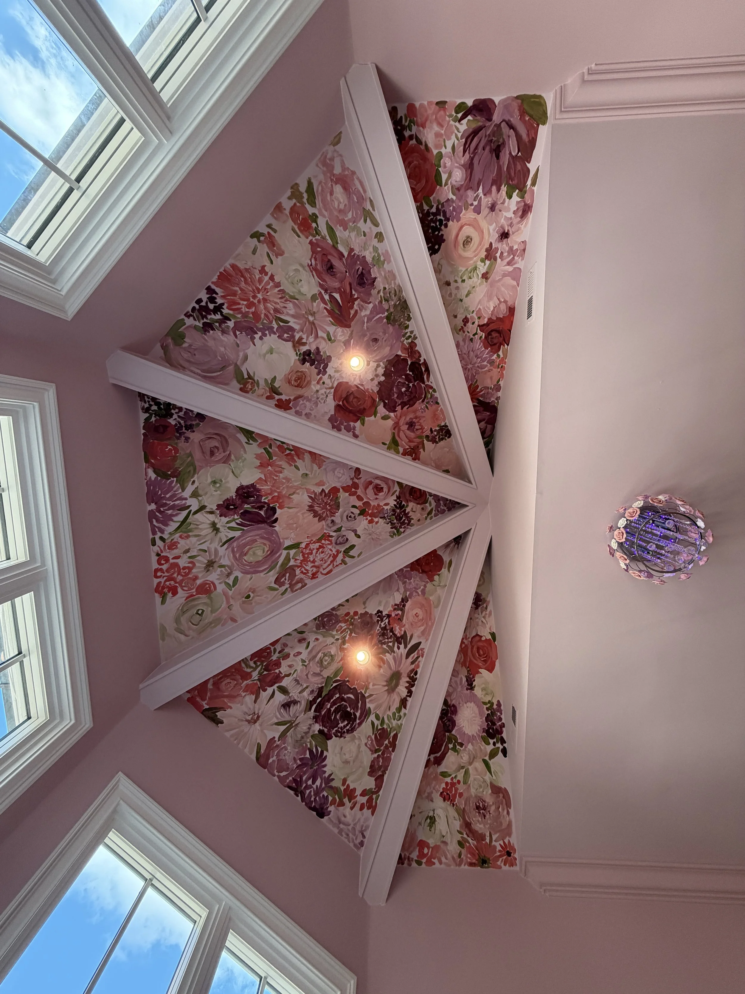 Ceiling mural of dozens of flowers in pink, red, white, and purple