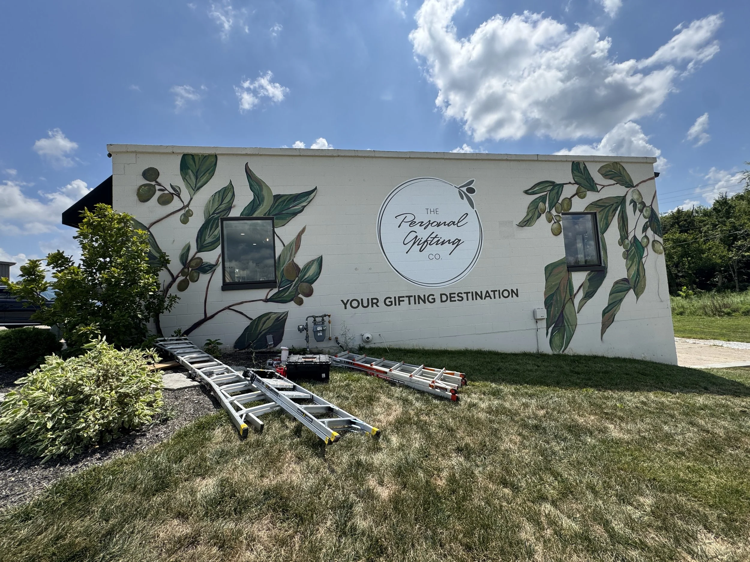 A mural of a outdoor wall that reads "The Personal Gifting Co – Your Gifting Destination"