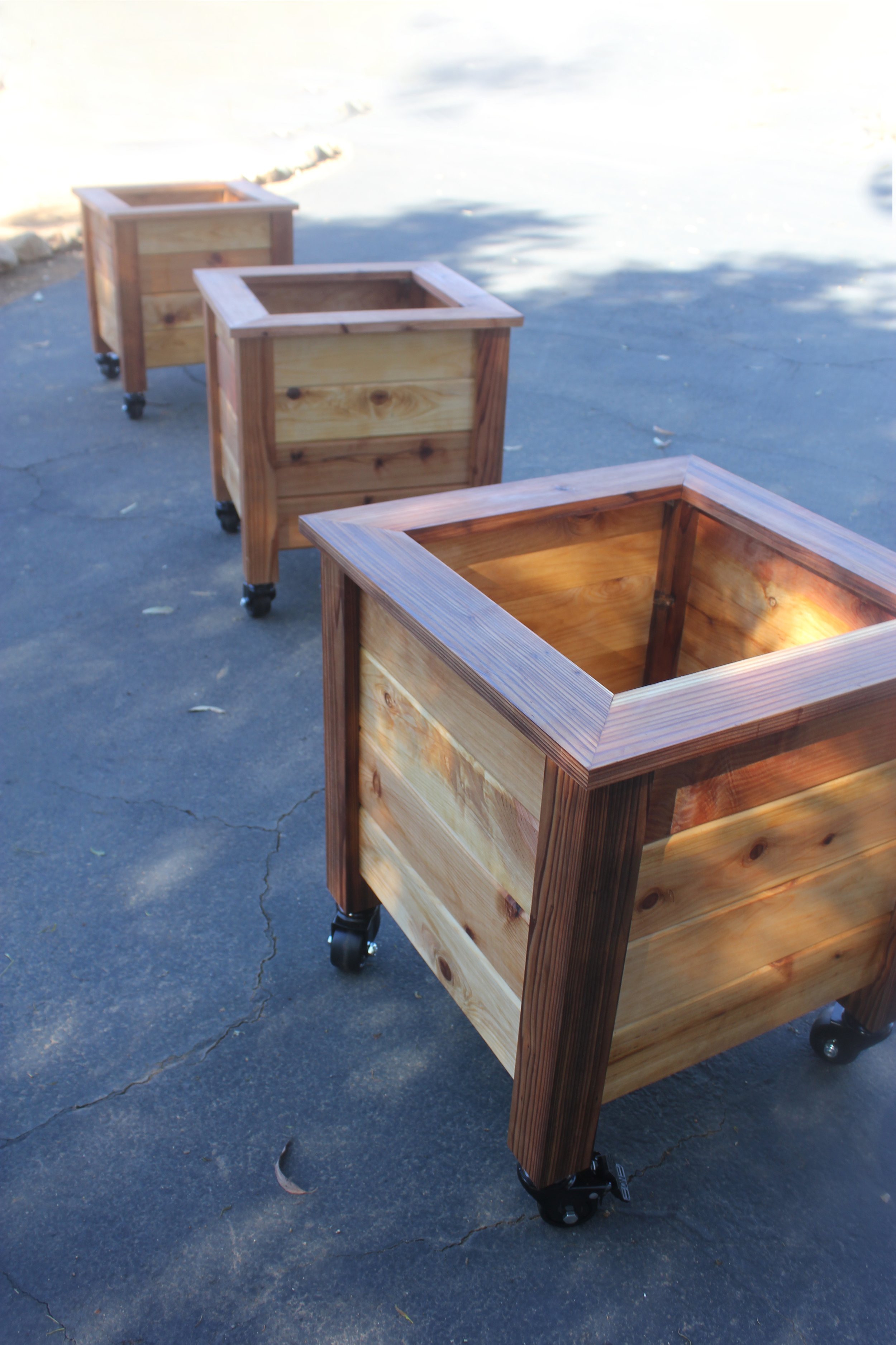 Wooden planters with casters, made of natural cedar wood.
