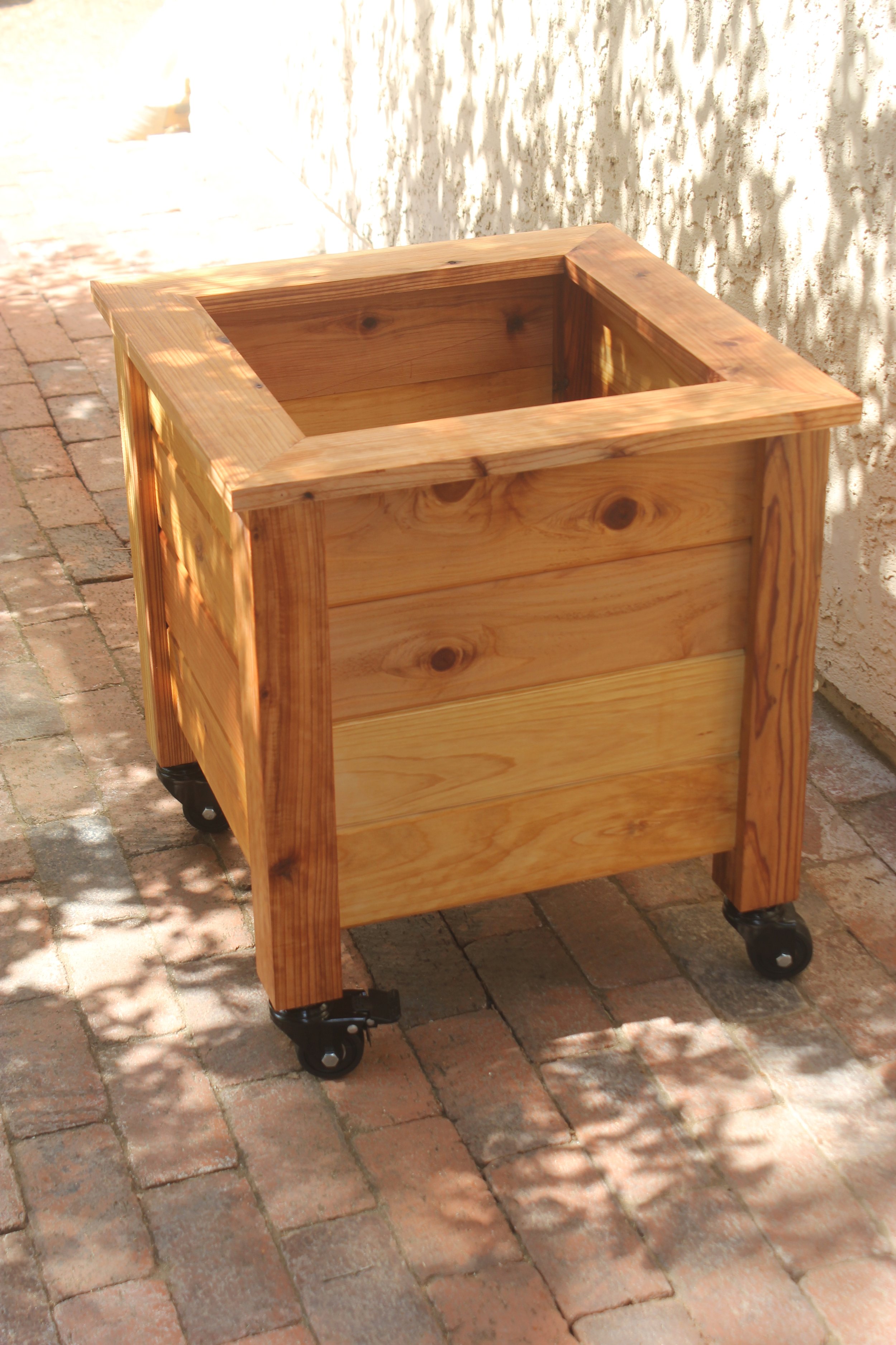 Wooden planters with casters, made of natural cedar wood. Ideal for patio and backyard gardening.
