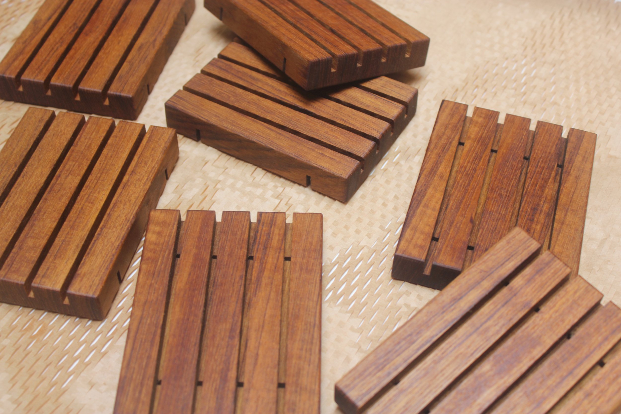 teak wooden soap trays in assorted sizes against a brown honeycomb paper packaging background.