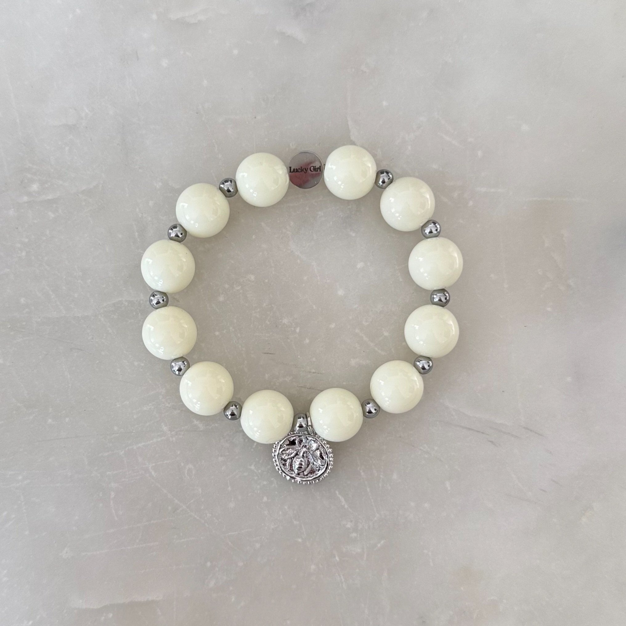 Ivory beaded bracelet with 4mm silver accent beads and a silver charm