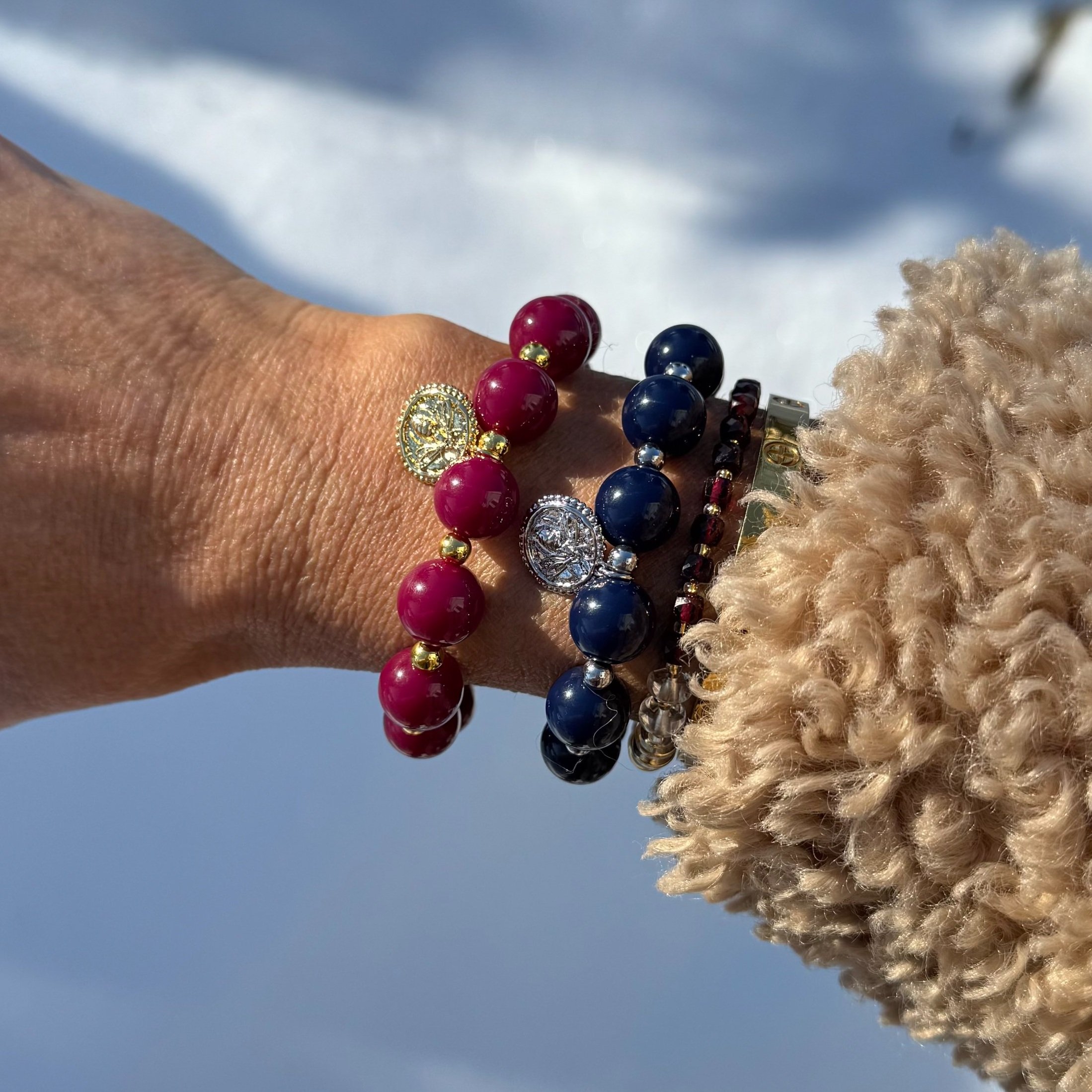 Navy and burgandy beaded charm bracelet show on wrist.