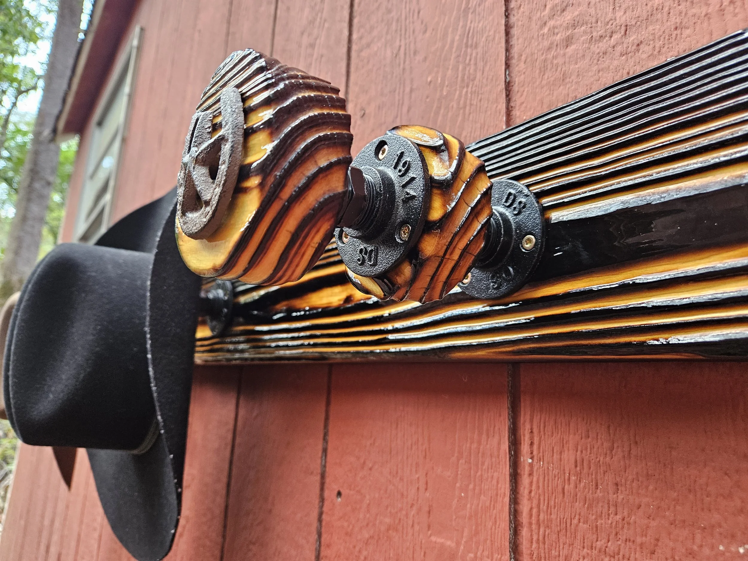 A close-up view of a guitar's body, focusing on the tuning pegs and the strings, with a wooden surface in the background.
