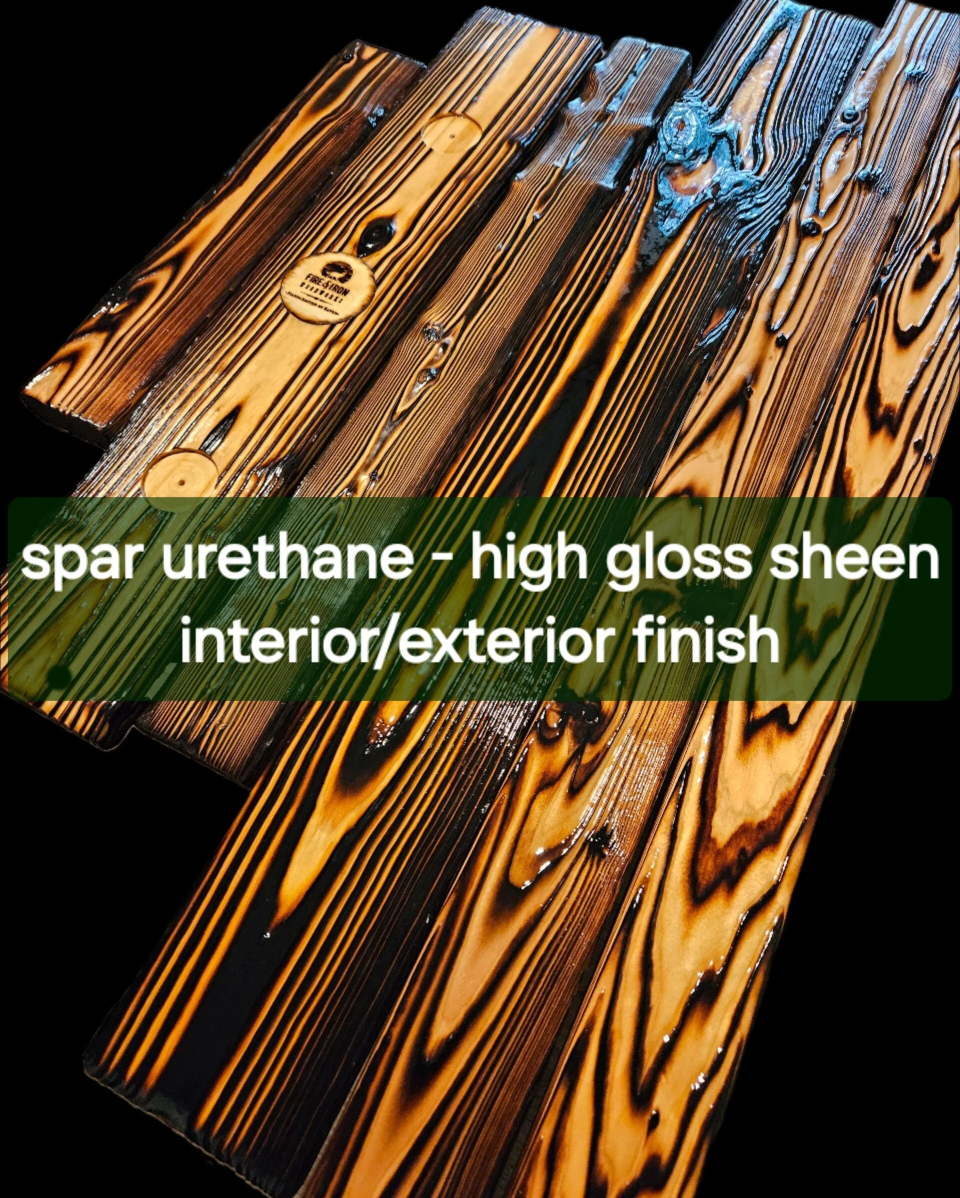 Close-up of a high gloss finished wood surface with dark and light streaks, showing the grain pattern and a small circular logo sticker reading 'Fire & Iron'.
