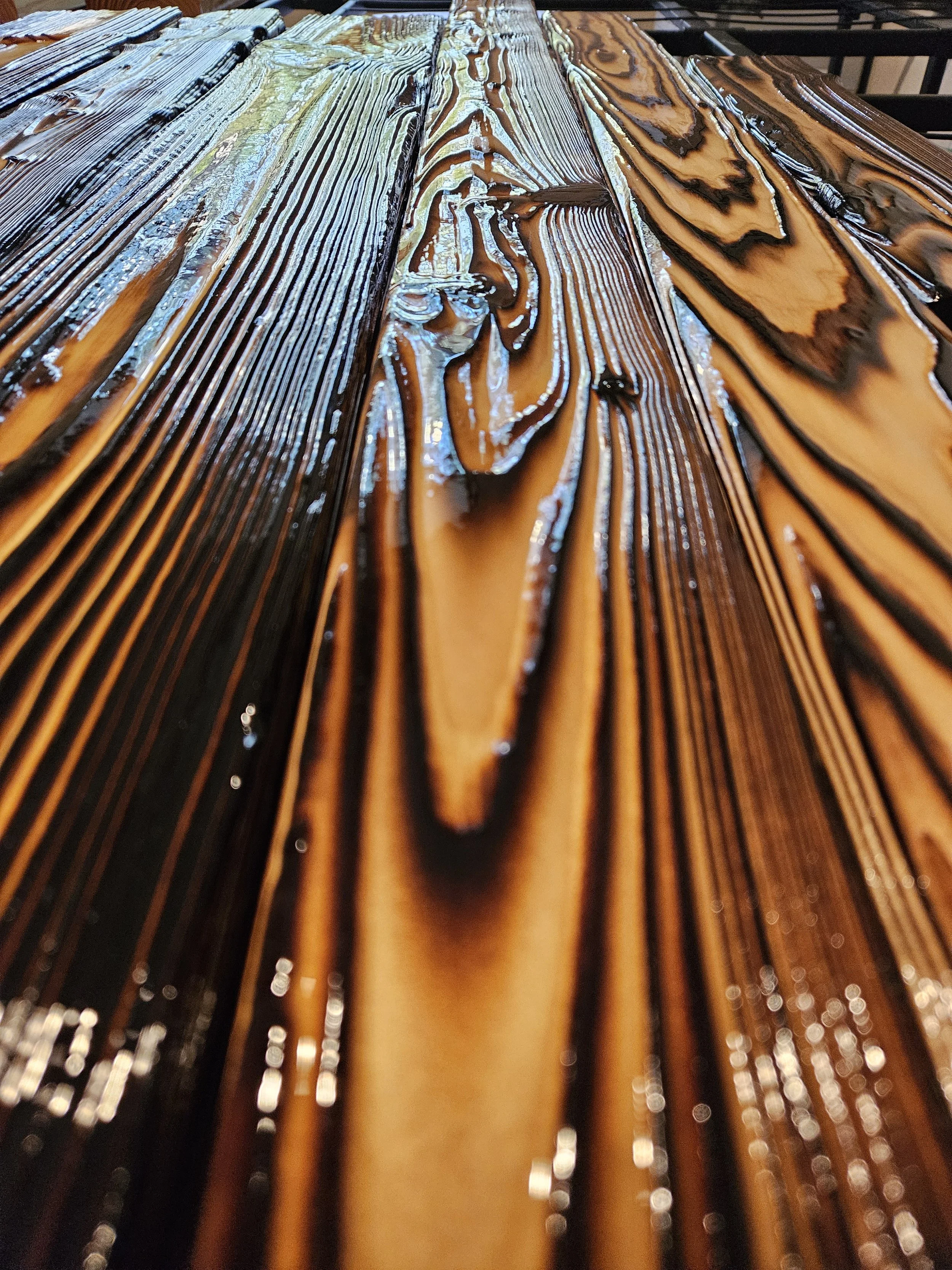 Close-up view of wet wooden table planks showing detailed wood grain patterns with water reflecting light.