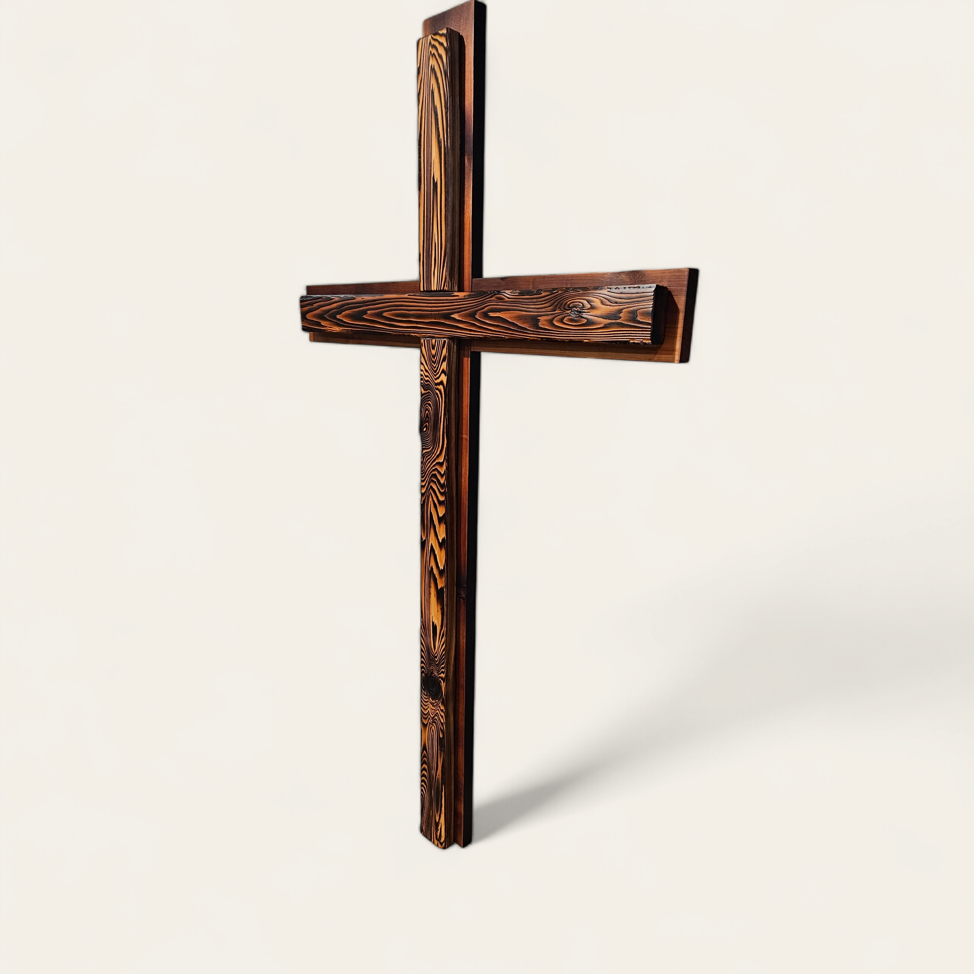 A wooden cross with a natural wood grain finish against a plain white background.