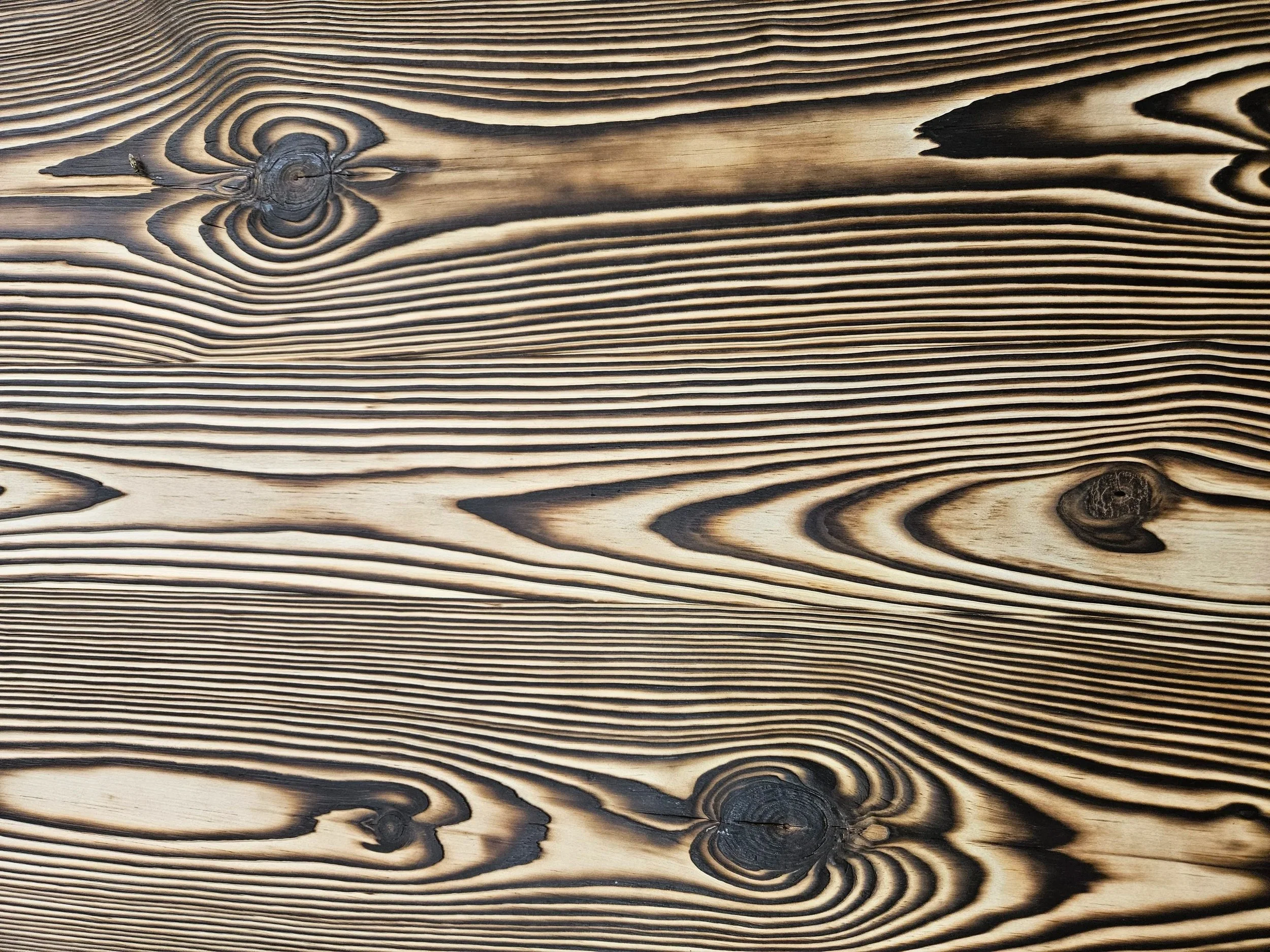 Close-up of FireForged™ wood showing flowing raised grain and natural texture.