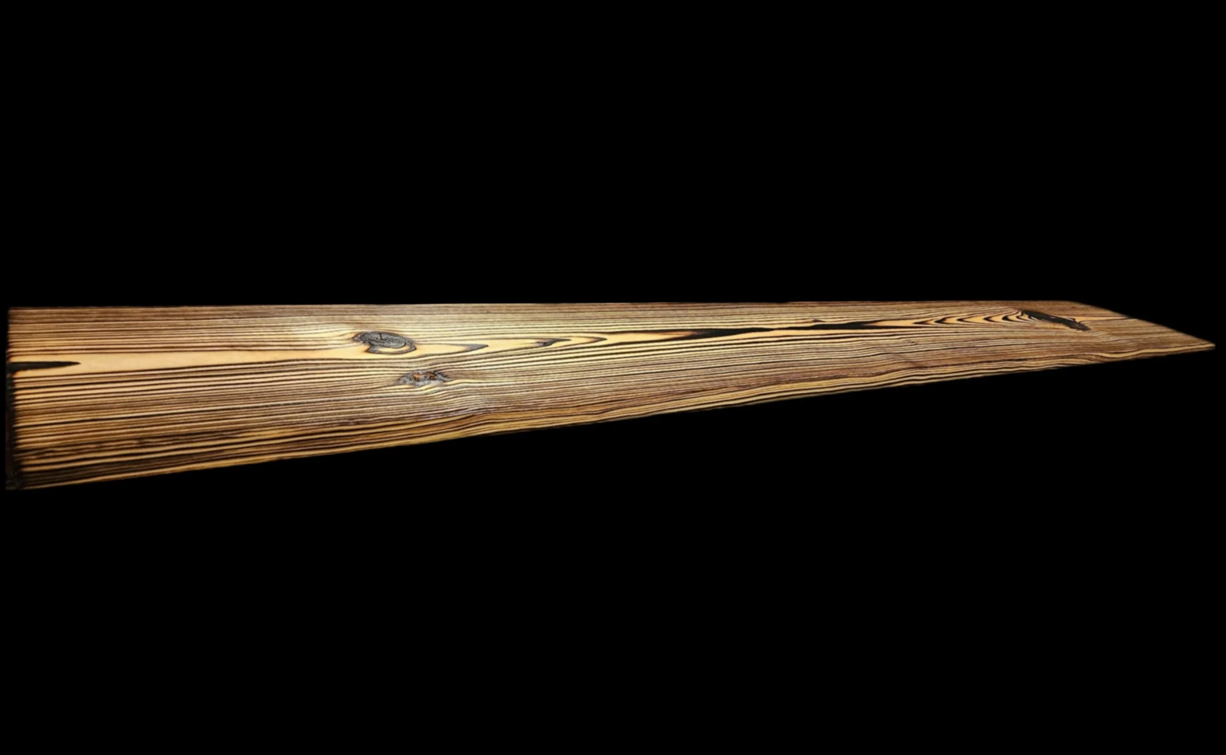 Close-up shot of a wooden board with visible wood grain, knots, and a smooth finish, against a black background.
