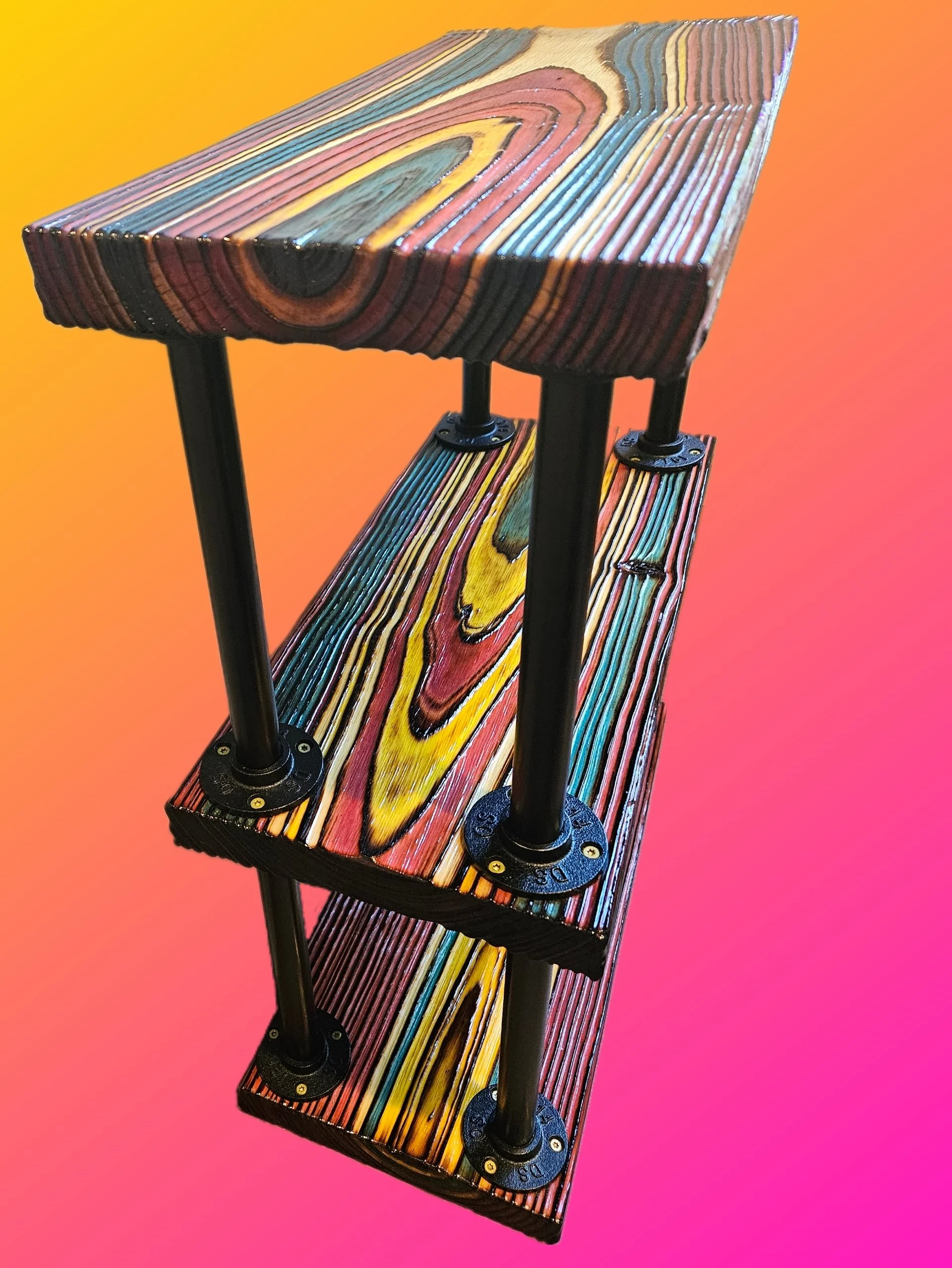 Colorful wooden desk with black metal legs against a yellow to pink gradient background.