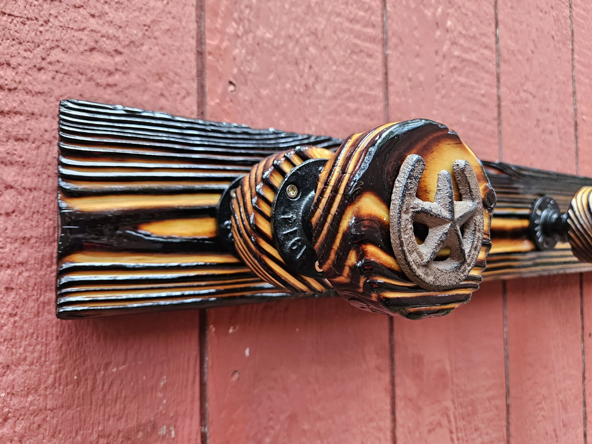 Close-up of a vintage-style fire hose nozzle resting on a red brick surface.