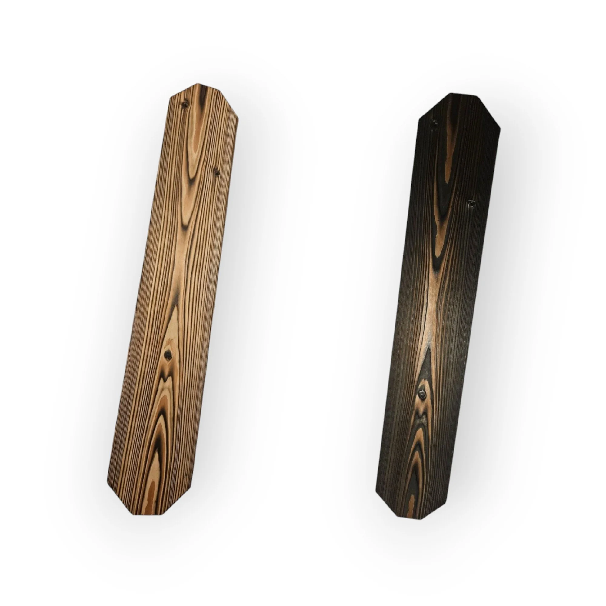 Two wooden posts, one light-colored and one dark-colored, are angled diagonally upwards from face-on perspective against a plain white background.