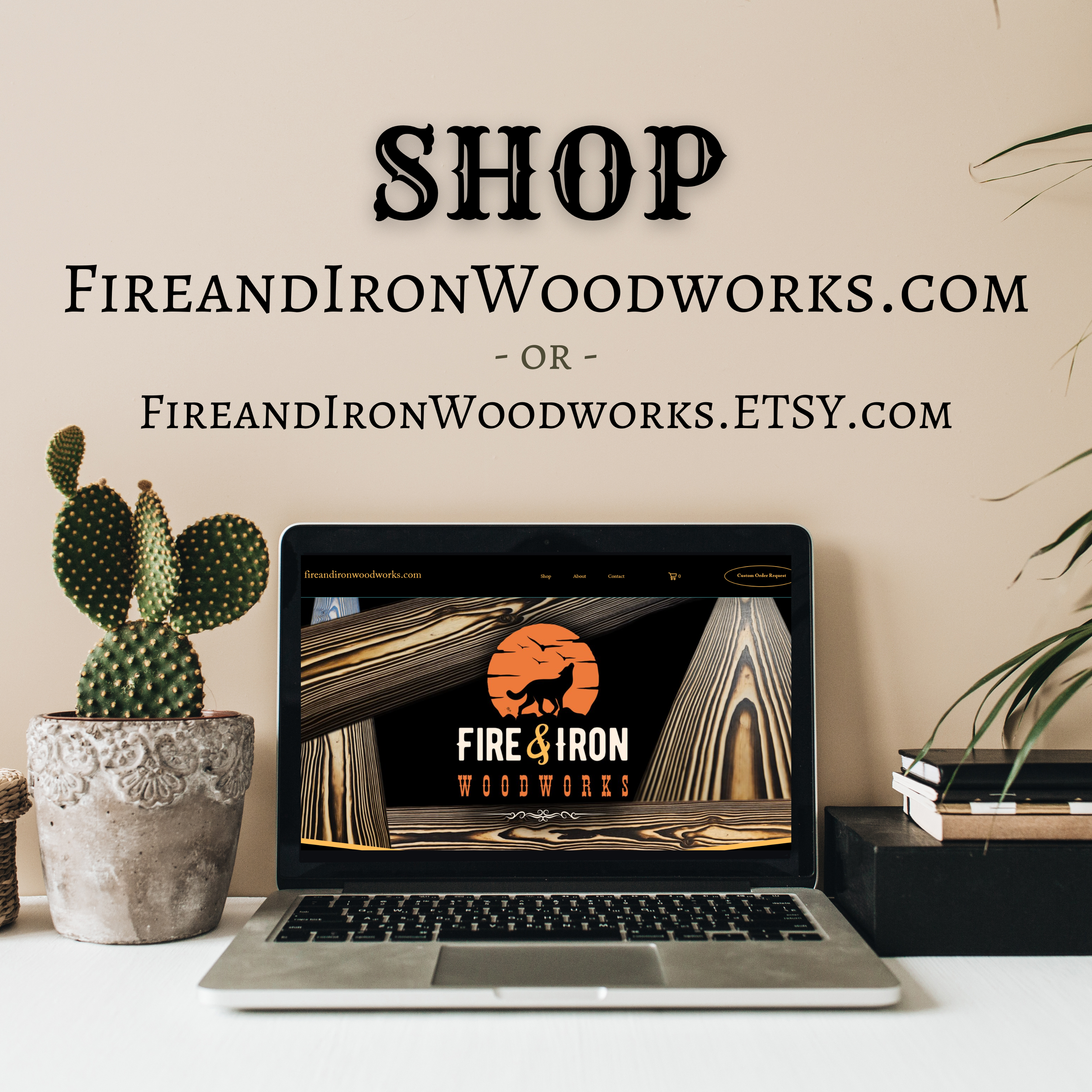 A workspace with a laptop, a potted cactus, and a potted plant on a white desk against a beige wall with a sign for Fire and Iron Woodworks.