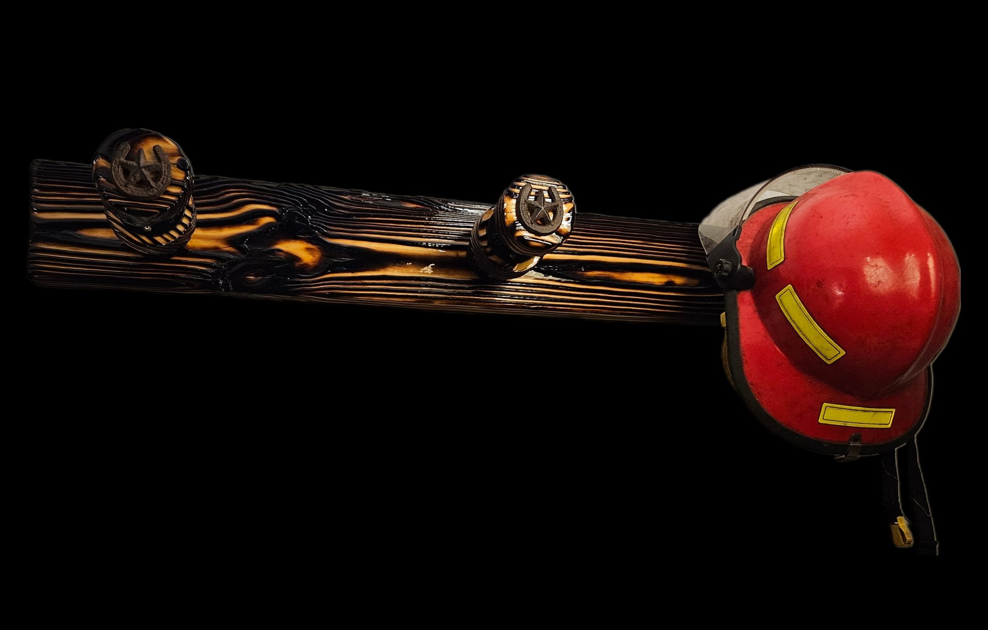 A wooden fire hydrant with firefighter helmet resting on top, black background