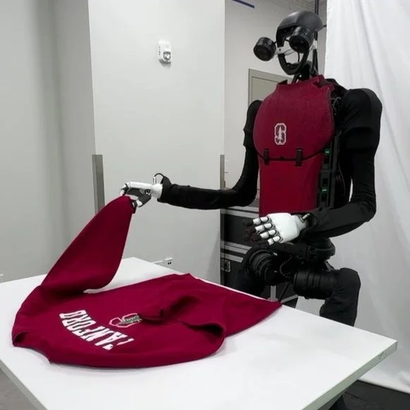 static image of the h1 humanoid folding a stanford jacket