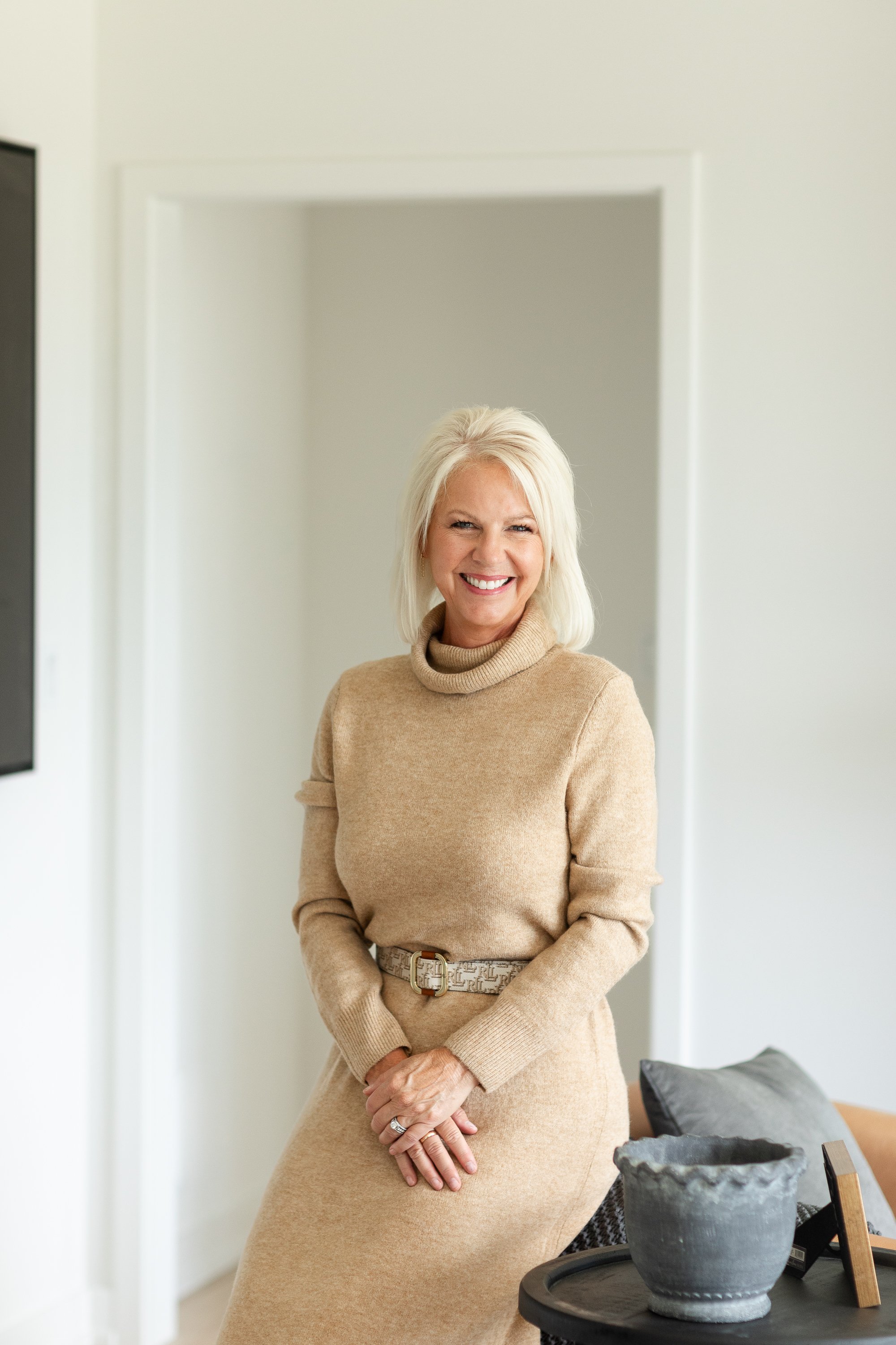 Beth Arey leaning against a sofa on a home finalizing Day.