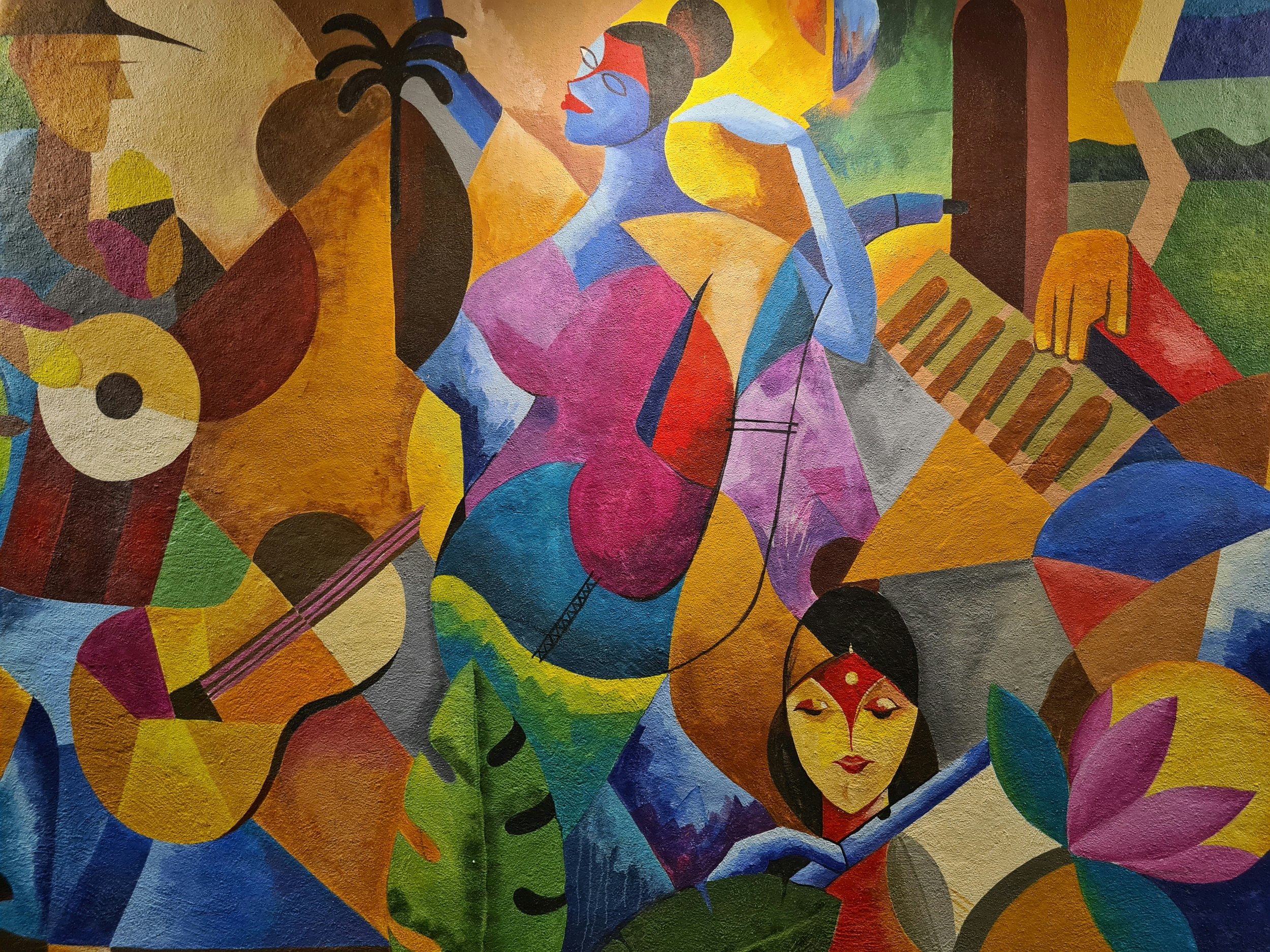 Colorful abstract mural featuring stylized human figures, musical instruments, and vibrant geometric shapes.