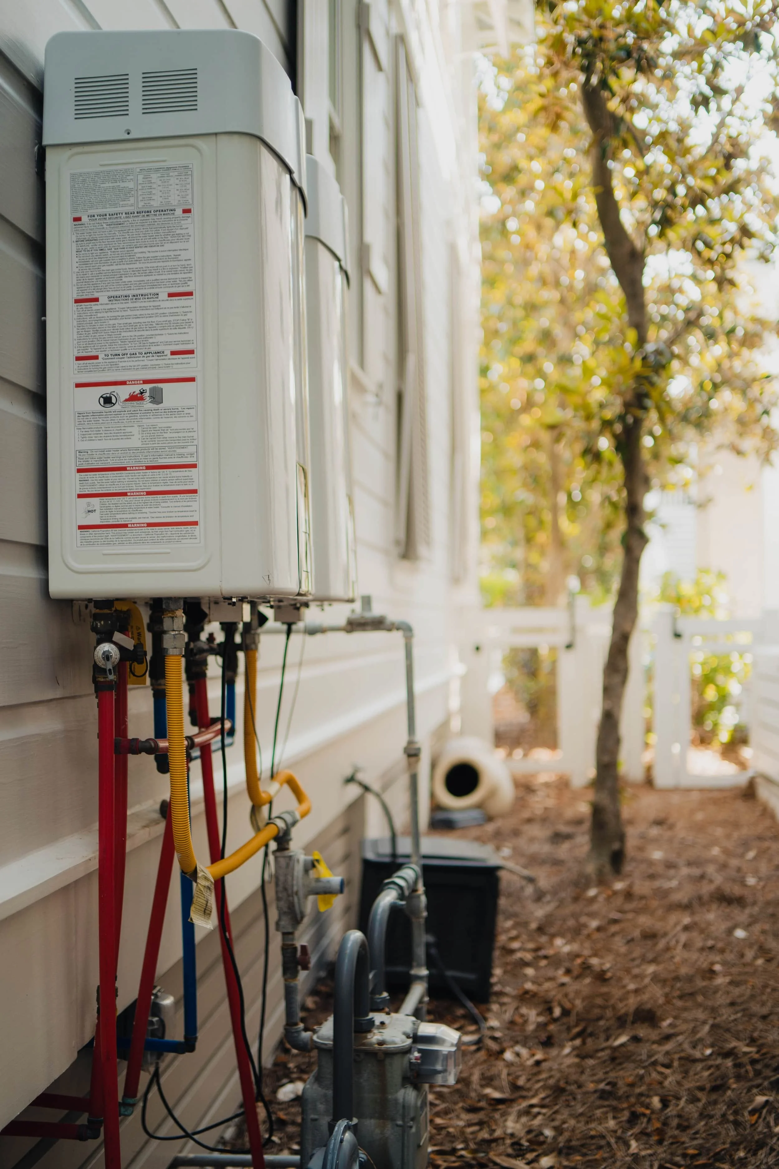 water heaters installed outside of home with pipes