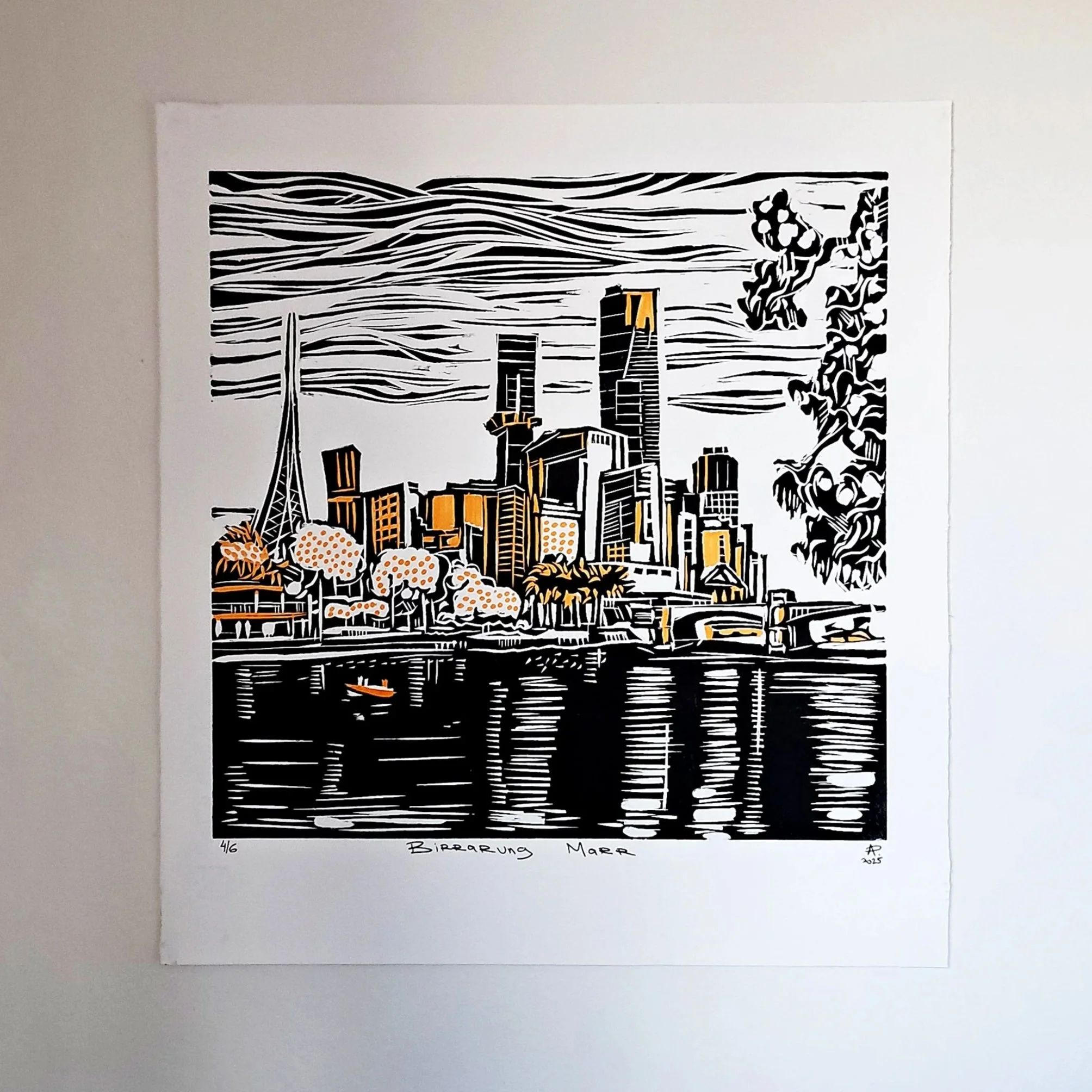 Black and white print of Melbourne skyline with buildings, trees, and water, with some orange highlights.